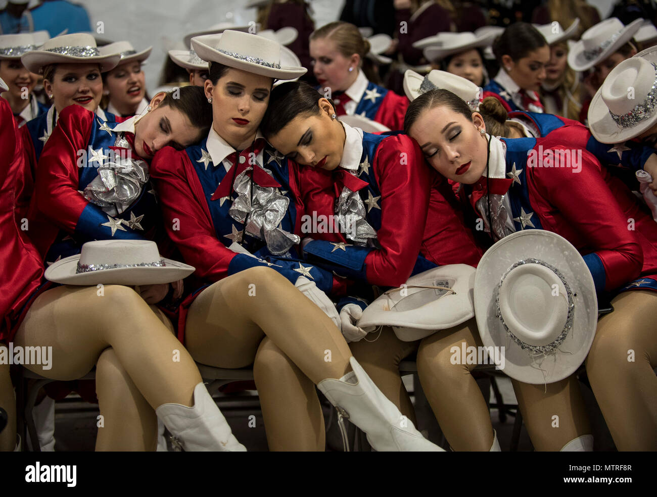 Raiders dancers from West Monroe High School, Louisiana, take a nap before the start of the 58th