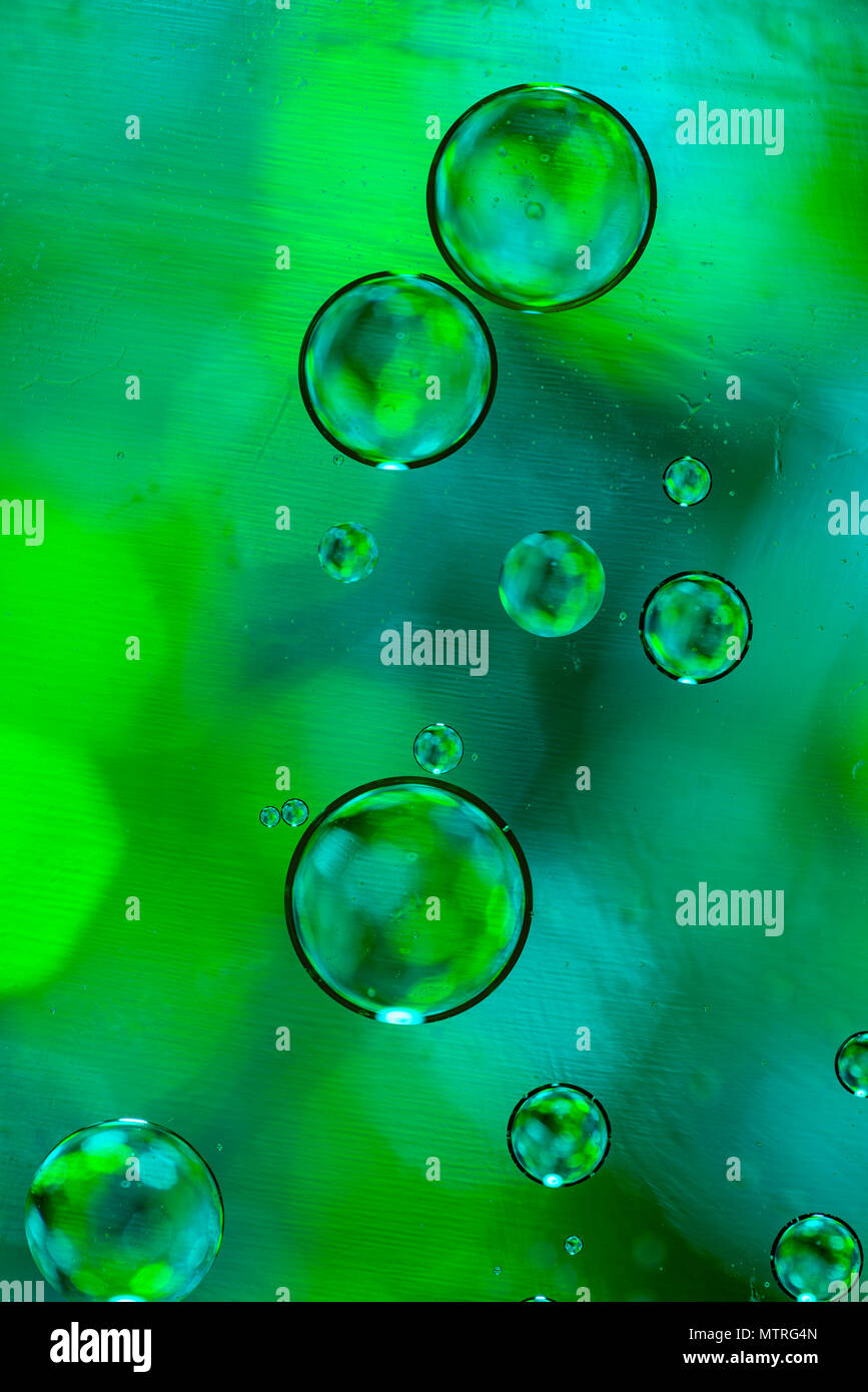 Water drops on glass with a green and blue lighted background. Stock Photo
