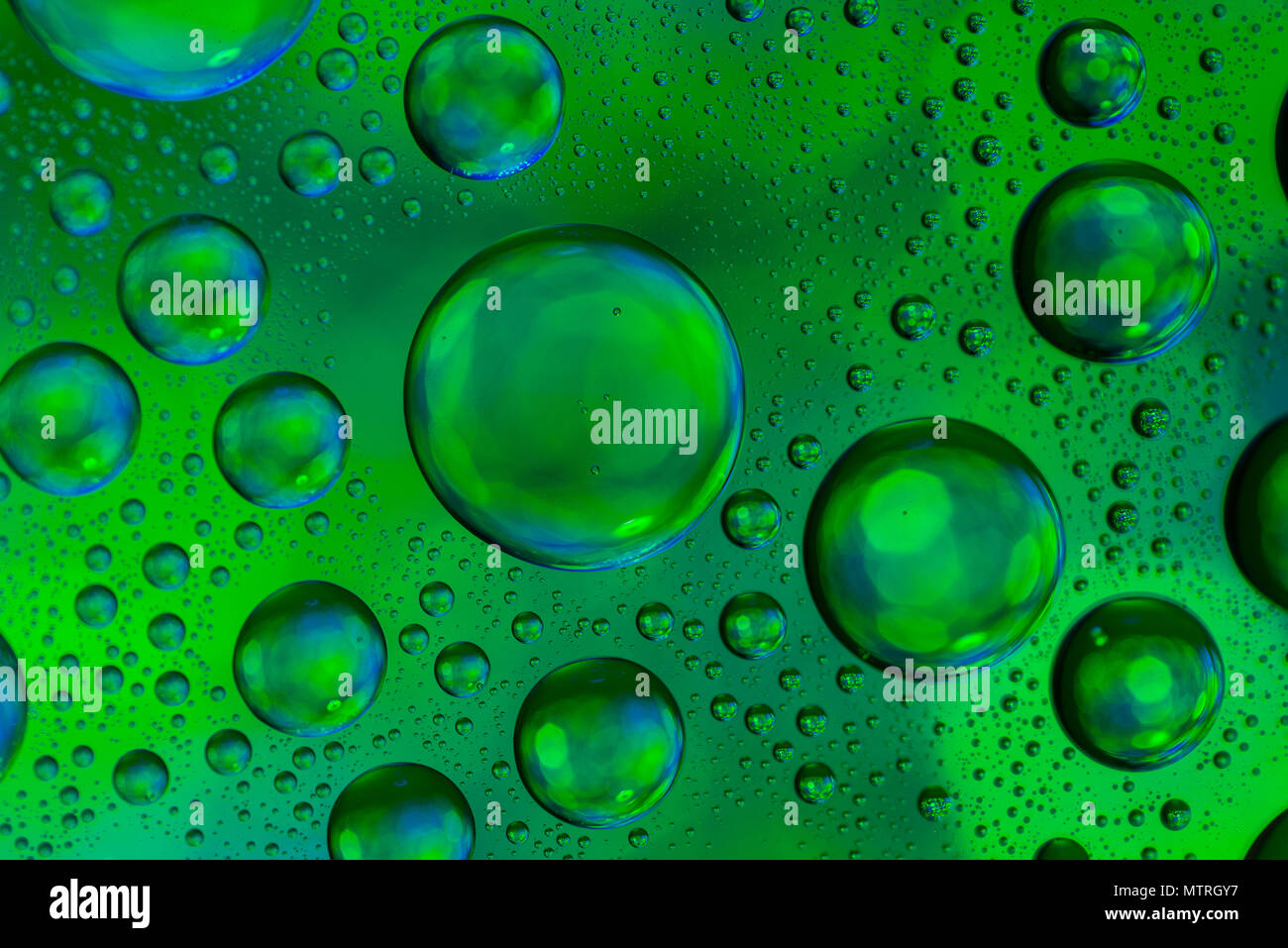 Water drops on glass with a green and blue lighted background. Stock Photo