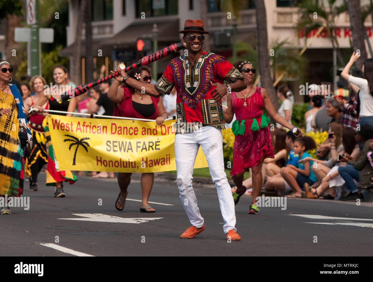 HONOLULU — Telepharoah Brandon, a member of Sewa Faré, a West African Dance and Drum group, marches in the Martin Luther King Jr. Holiday Parade in Waikiki, Jan. 16, 2017. Brandon holds a Samoan fireknife practice staff and wears a dashiki to represent African, American and Polynesian unity. The parade, which ran from Magic Island at Ala Moana Beach Park to Kapiolani Park, included a unity rally. Attendees at the rally partook in food and entertainment at Kapiolani Park. (U.S. Army photo by Kristen Wong)   Stock Photo