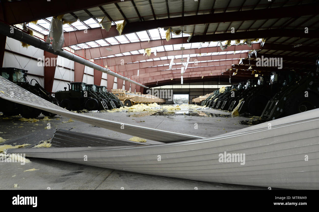 A structure housing military vehicles is severely damaged after a