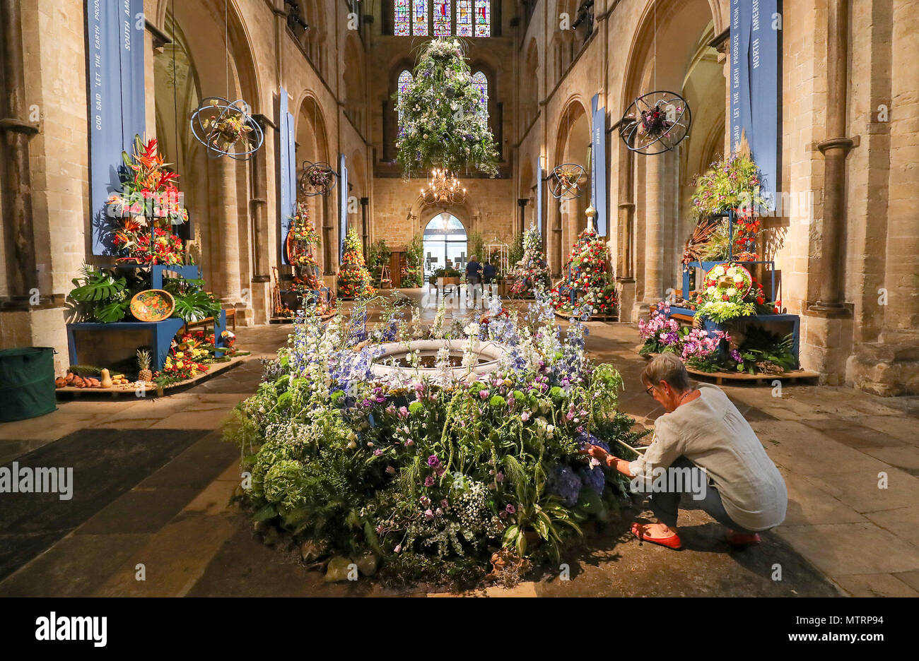 Final preparations are made to displays inside Chichester Cathedral, as it is filled with 80 flower arrangements using over 50,000 flowers, to celebrate its annual Festival of Flowers, which this year has a theme of 'This Earthly Paradise'. Stock Photo