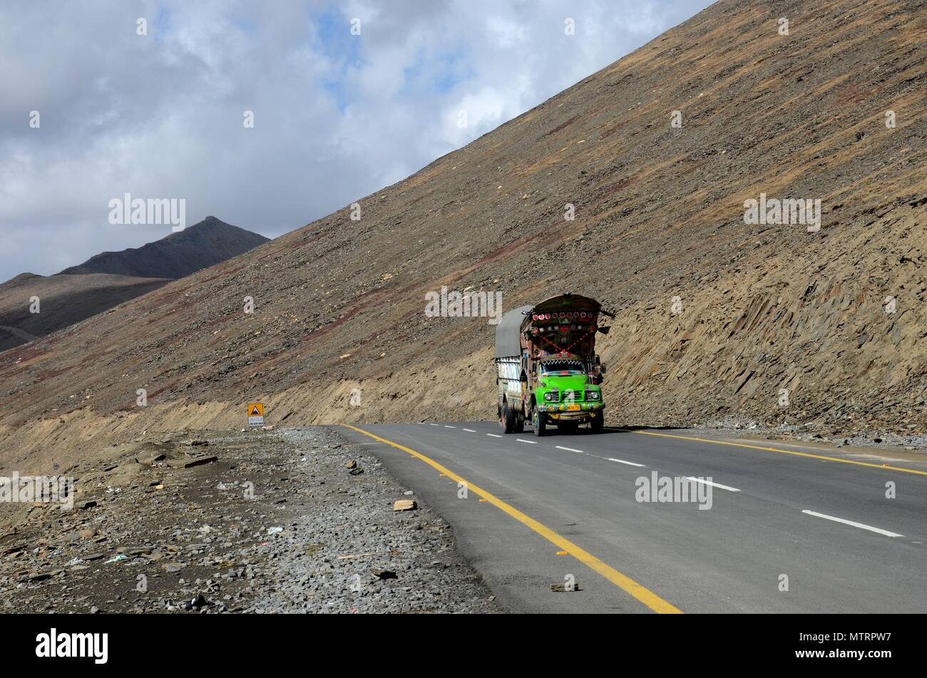Green Bedford decorated goods truck on Karakoram Highway amid mountains Babusar Pass north Pakistan Stock Photo
