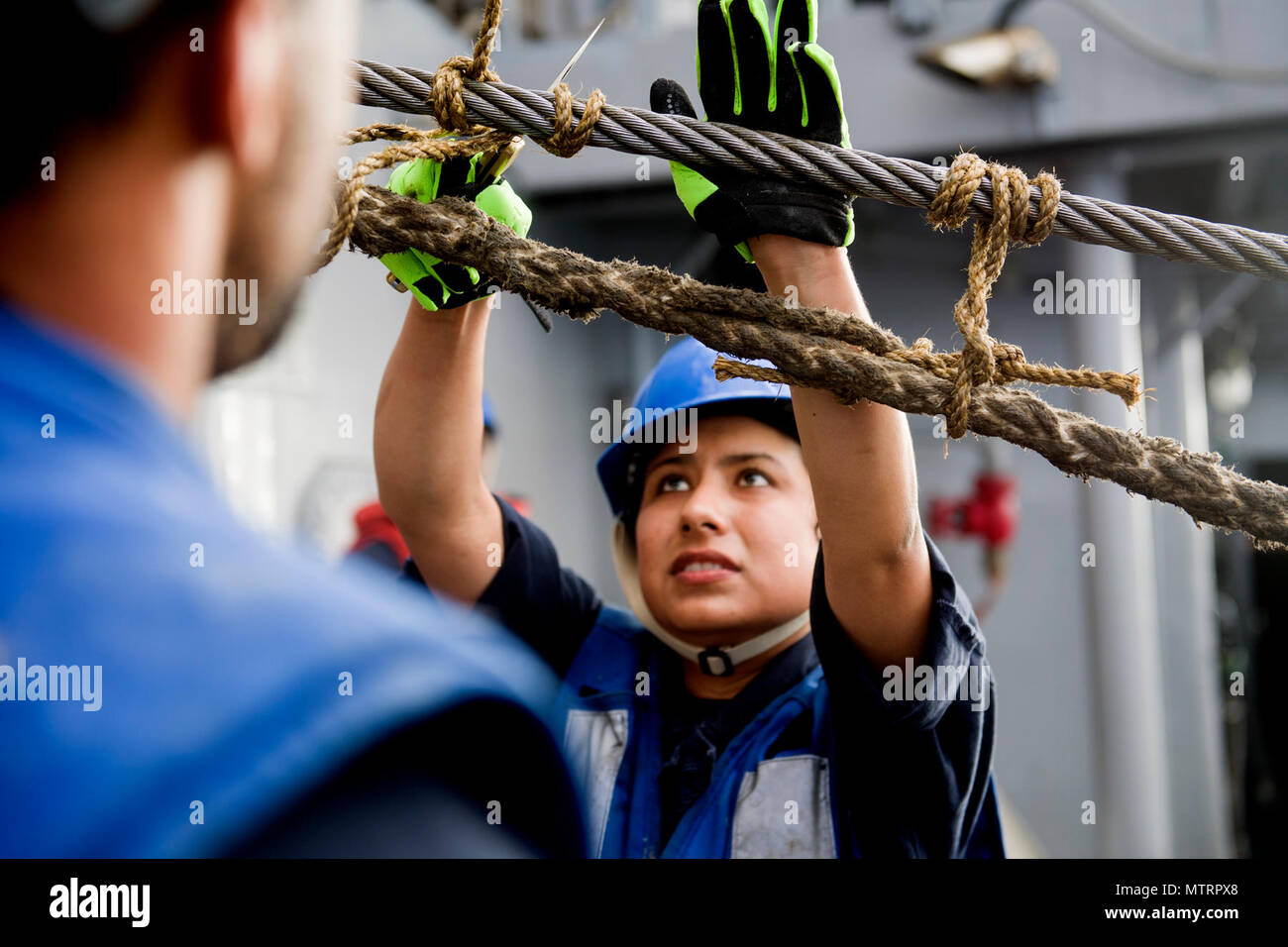 170118-N-FT178-078 PACIFIC OCEAN (Jan. 18, 2017) Boatswain's Mate Seaman Apprentice Athalia Chavez cuts a messenger line from the span wire aboard Ticonderoga-class guided-missile cruiser USS Lake Champlain (CG 57) during a replenishment-at-sea. Lake Champlain is on a regularly scheduled Western Pacific deployment with the Carl Vinson Carrier Strike Group as part of the U.S. Pacific Fleet-led initiative to extend the command and control functions of the U.S. 3rd Fleet in the Indo-Asia-Pacific region. (U.S. Navy photo by Mass Communication Specialist 2nd Class Nathan K. Serpico/Released) Stock Photo