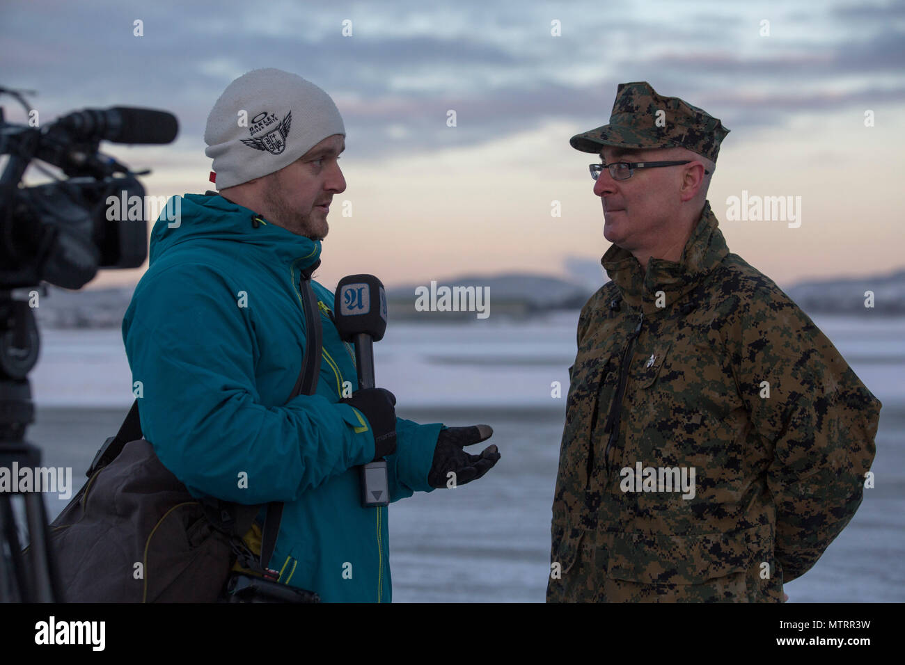 Colonel Doug Brunn talks with a local news station on the tarmac at Vaernes Garnison, Norway, Jan. 16, 2017. The U.S. Marines with Black Sea Rotational Force 17.1 arrived at Vaernes Garnison early in the morning as part of Marine Rotational Force Europe 17.1. (U.S. Marine Corps photo by Lance Cpl. Victoria Ross) Stock Photo