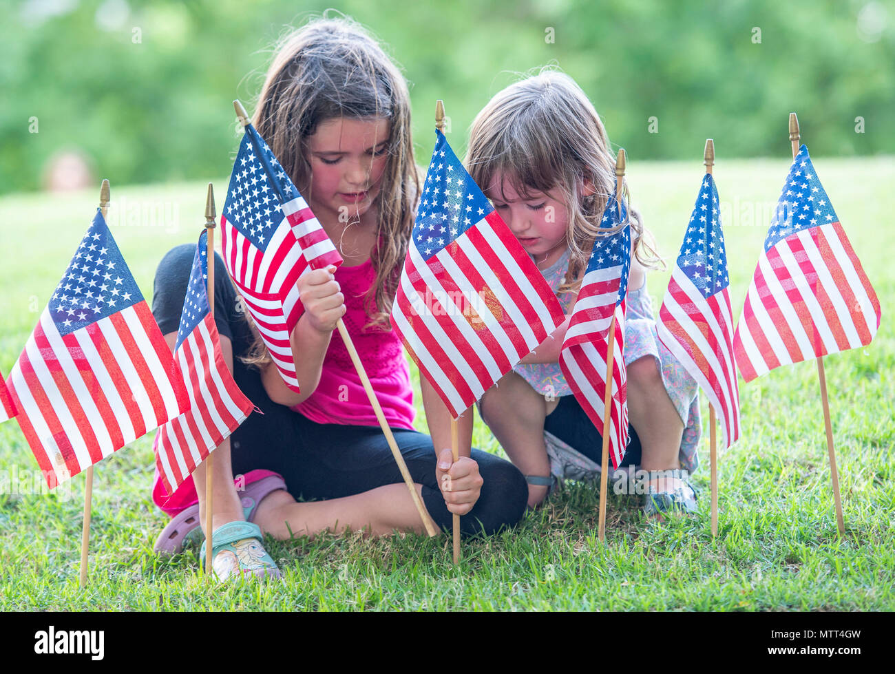 Anne Michelle Aiken 7 and Lilly Aiken 4 place American flags