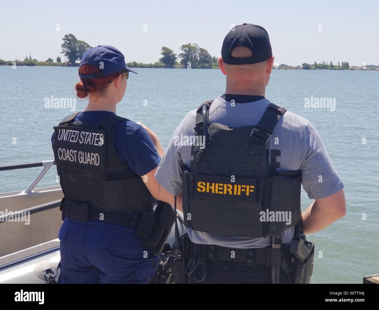 Petty Officer 3rd Class Iris Bahr of Coast Guard Station Rio Vista and Mike Keegan of the Sacramento County Sheriff’s Marine Unit watch over the Delta Waterway in Rio Vista, California, May 22, 2018 during National Safe Boating Week.  The Coast Guard works closely with local law enforcement agencies to collaboratively patrol waterways and promote boating safety.  (Coast Guard photo by Petty Officer 2nd Class Paul Krug) Stock Photo