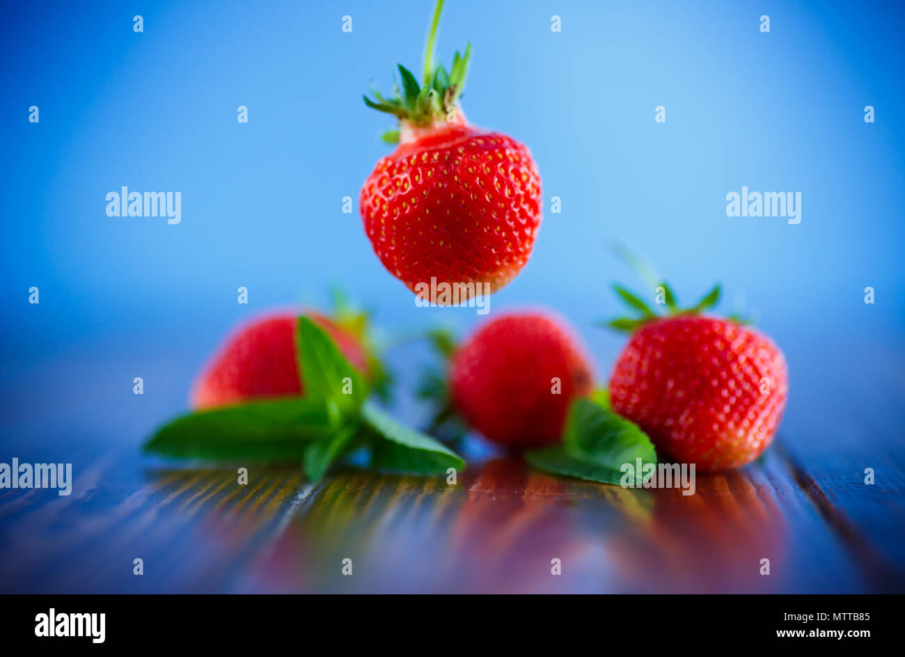 ripe red organic strawberry on a blue background Stock Photo