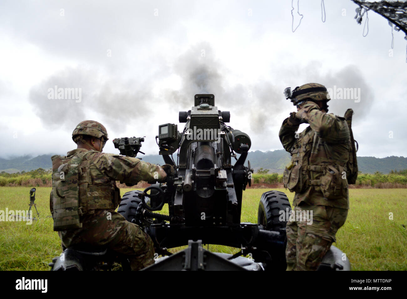 Spc. Nikko Impat (left), cannon crewmember, 3rd Battalion, 7th Field Artillery Regiment, 25th