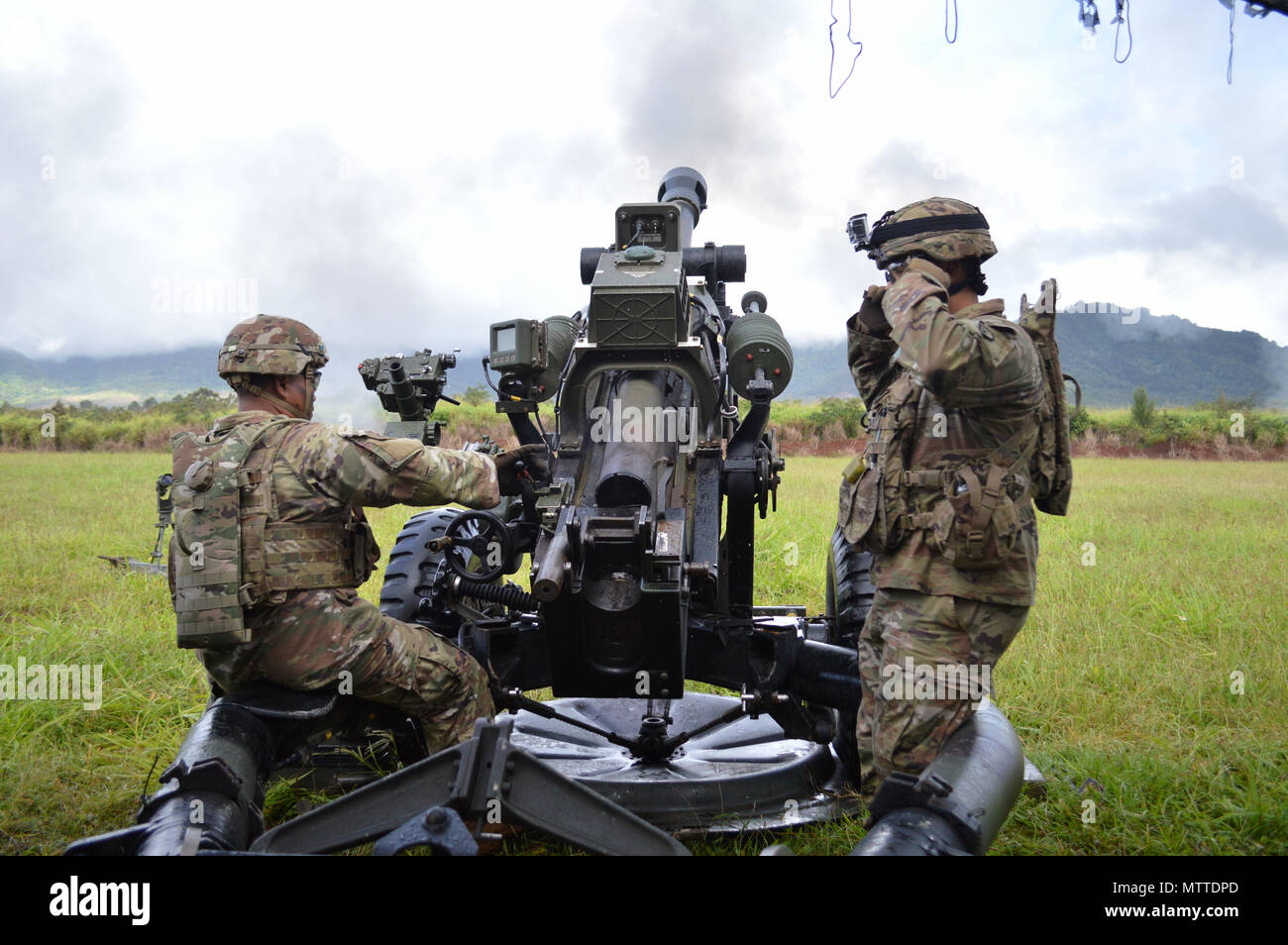 Spc. Nikko Impat (left), cannon crewmember, 3rd Battalion, 7th Field Artillery Regiment, 25th