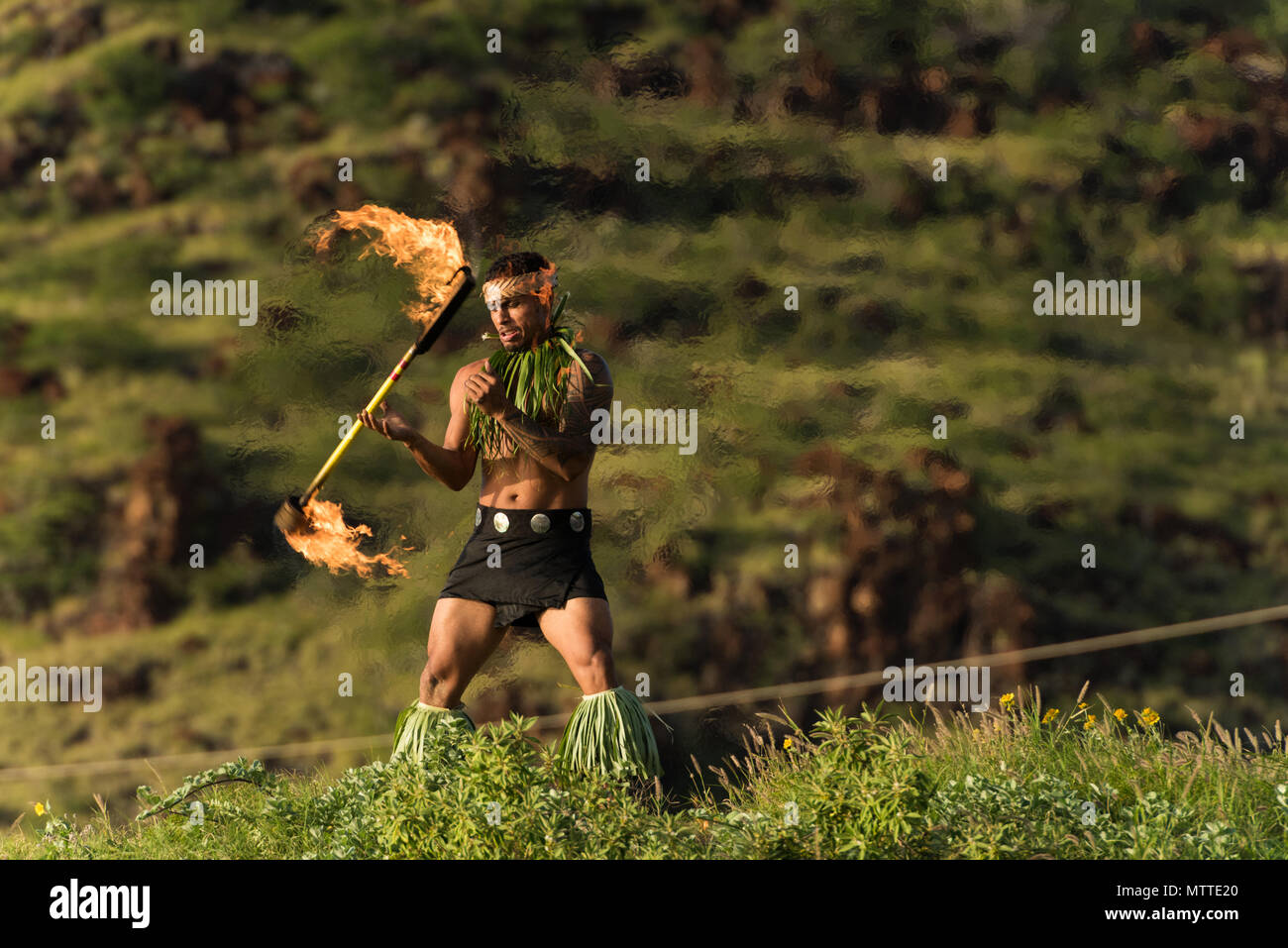 Male fire dancer performing with fire levi stick Stock Photo