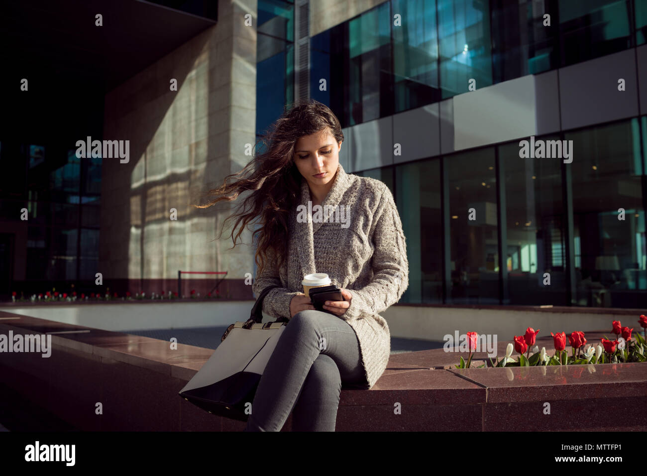 Focused woman sitting on city hi-res stock photography and images - Alamy