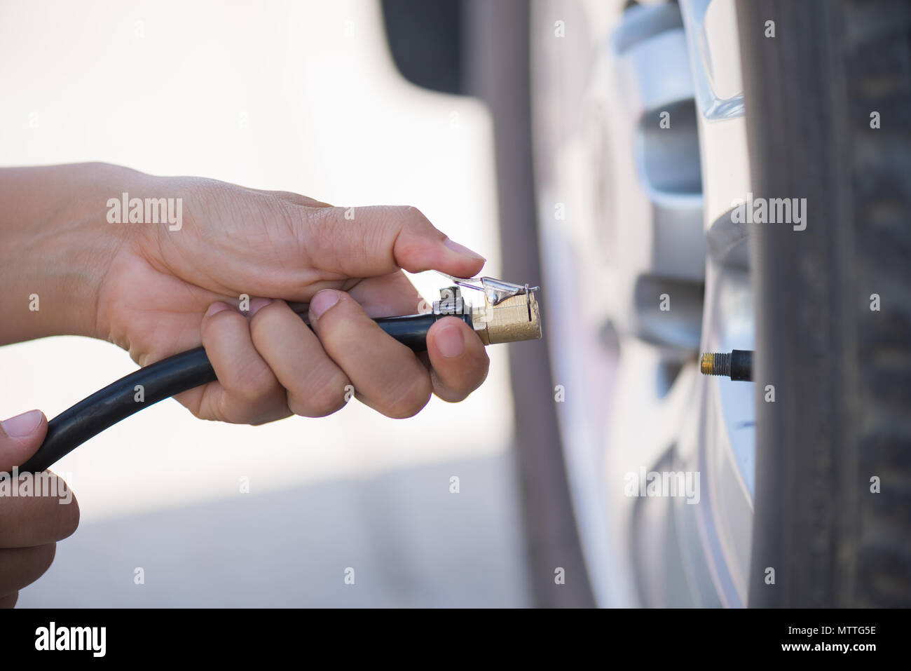 driver checking air pressure and filling air in the tires close up