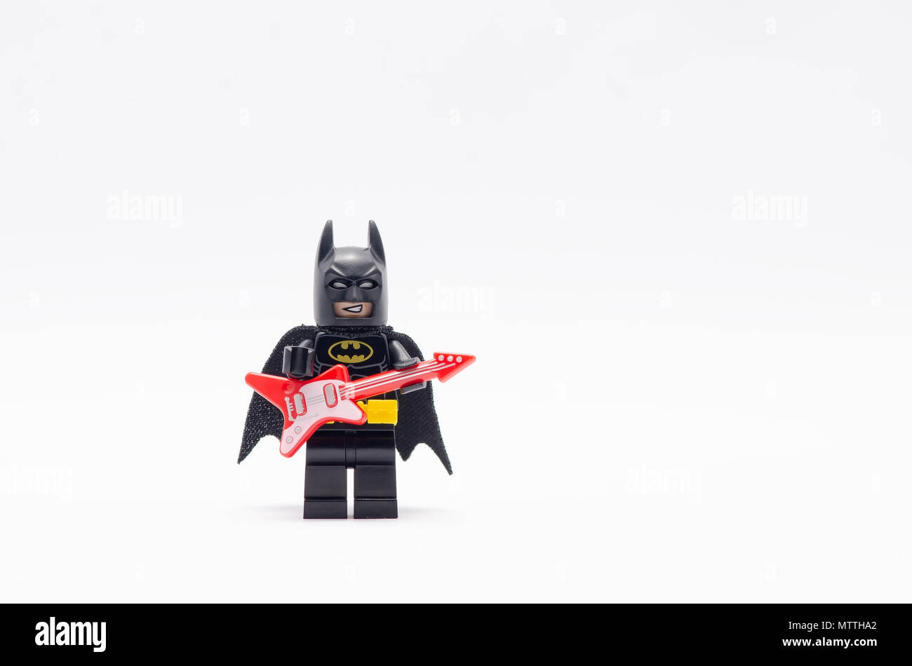 mini figure of  batman holding electric guitar. Lego minifigures are manufactured by The Lego Group. Stock Photo