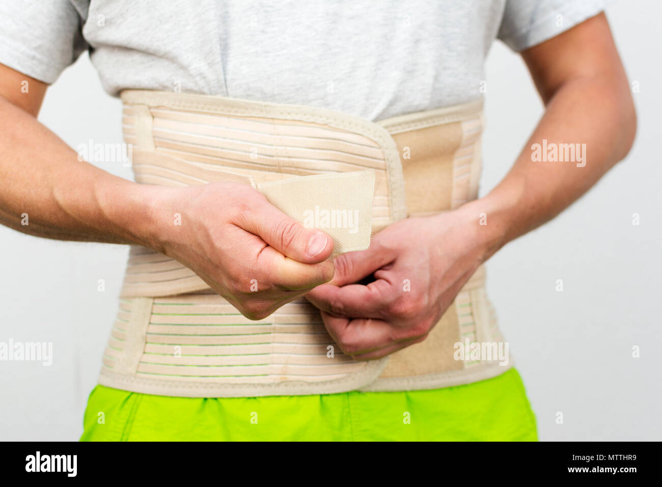 man dressing back support belt by his hands, front view Stock Photo