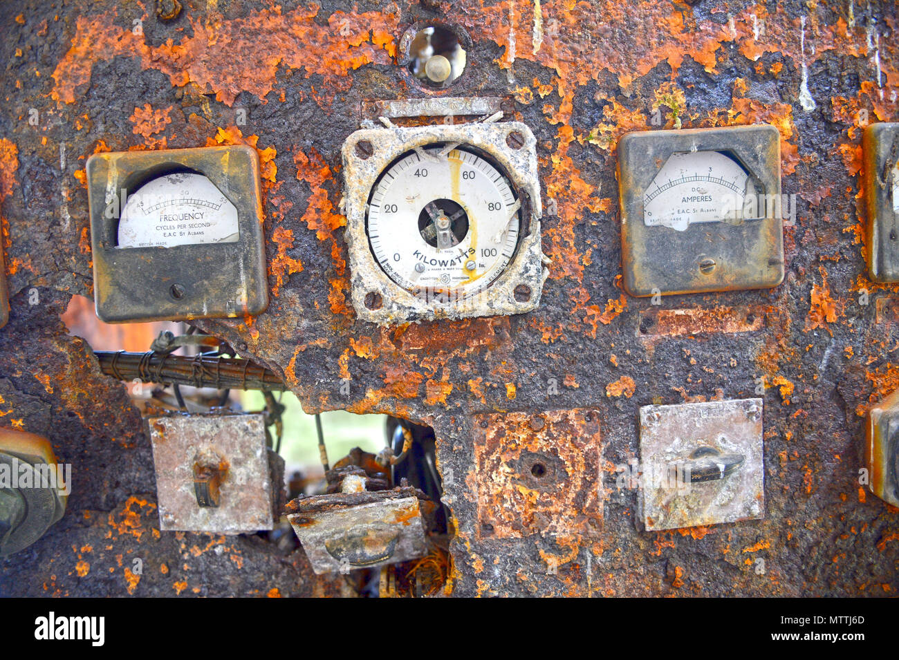 Old control panel rotted away with broken dials and falling apart in an