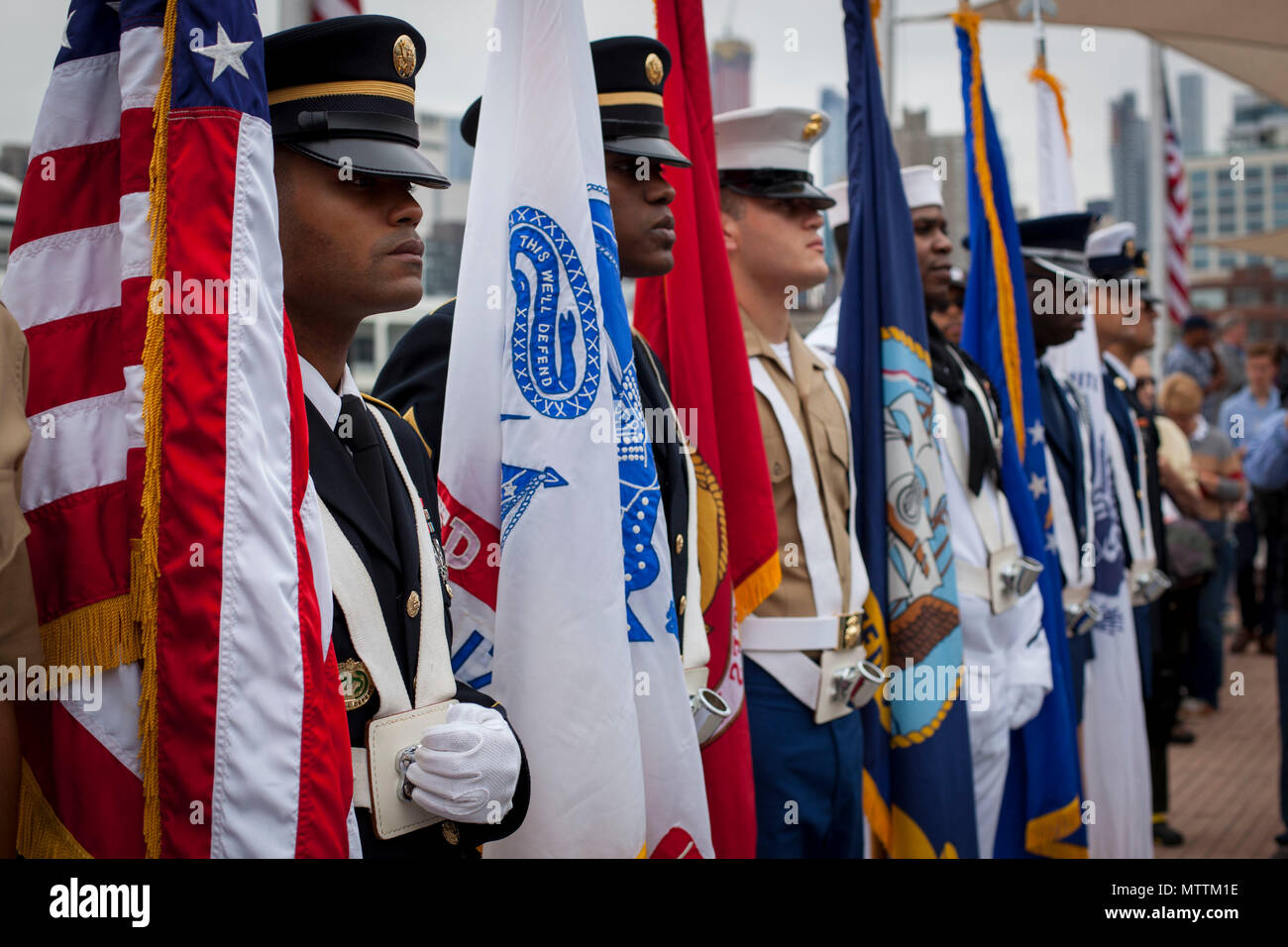 U.S. Marines, Sailors, Coast Guardsmen and Soldiers stand at attention