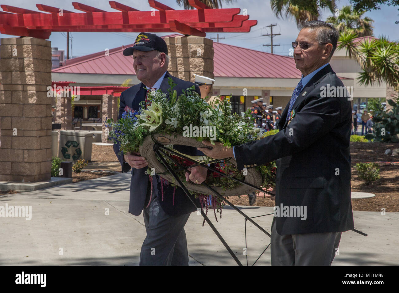 U.S. Marine Corps and Navy veterans lay a wreath by the 5th Marines Vietnam War Memorial during the unveiling ceremony in the Camp San Mateo Memorial Garden at Marine Corps Base Camp Pendleton, Calif., May 28, 2018. The memorial is inscribed with the names of 2,706 Marines and sailors who gave their lives serving our great nation. (U.S. photo by Lance Cpl. Rhita Daniel) Stock Photo