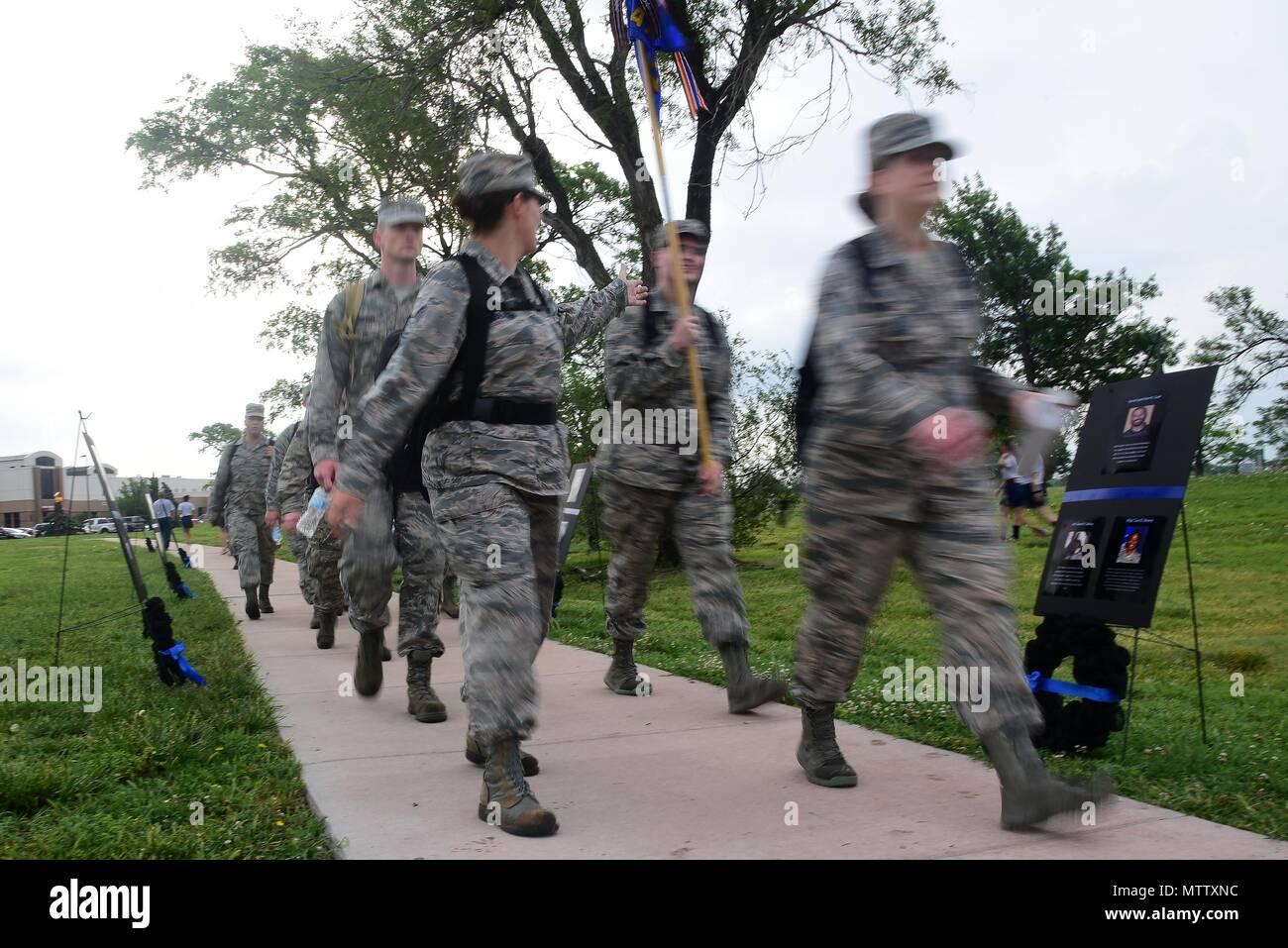 Team McConnell members walk past ceremonial wreaths May 16, 2018, at McConnell Air Force Base, Kansas, May 16, 2018. Each wreath was placed in honor of Airmen who died in 2015 during a motorcycle suicide bomber attack at Bagram Airfield and for two who passed in a C-130J Hercules crash near Jalalabad, Afghanistan in 2016. (U.S. Air Force photo by Airman 1st Class Alan Ricker). () Stock Photo