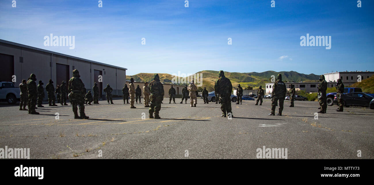 U.S. Marines from 1st Maintenance Battalion, 1st Marine Logistics Group, gather trainees to conduct Reconnaissance, Surveillance and Decontamination Training aboard Marine Corps Base Camp Pendleton, Calif., April 26, 2017. The trainees are receiving one final brief before separating into their training groups. The purpose of this training is to accomplish missions within a chemical, biological, radiological and nuclear environment. Stock Photo