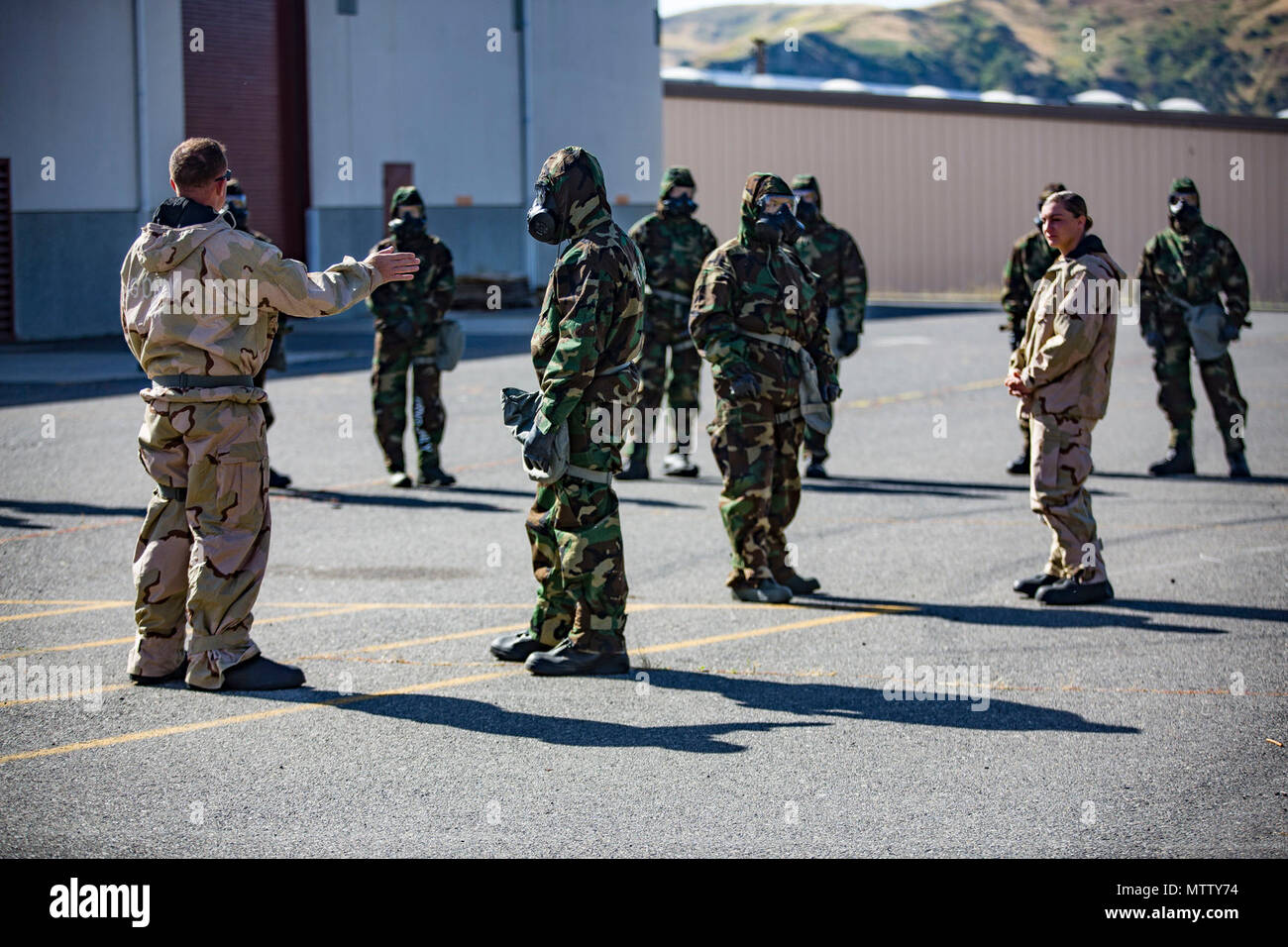 U.S. Marine Staff Sgt. Philip Barnes (left) instructs trainees in order to conduct the Reconnaissance, Surveillance and Decontamination Training aboard Marine Corps Base Camp Pendleton, Calif., April 26, 2017. Barnes goes over different safety precautions, prior to the trainees separating into their different training groups. The purpose of this training is to accomplish missions within a chemical, biological, radiological and nuclear environment.  Barnes is the current CBRN chief for 1st Maintenance Battalion, 1st Marine Logistics Group. Stock Photo
