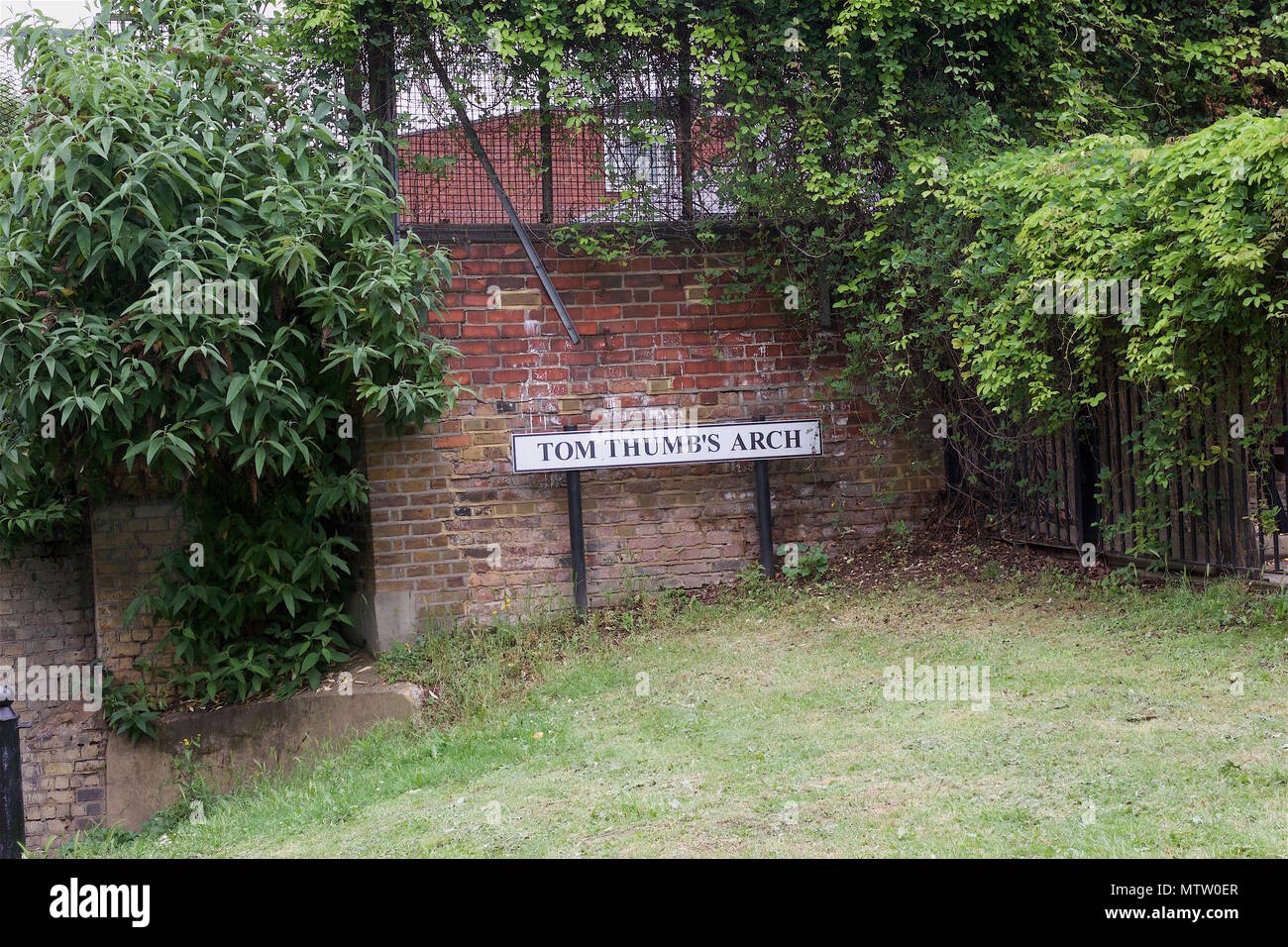 The road sign for Tom Thumb's Arch, a pedestrian walkway under a bridge