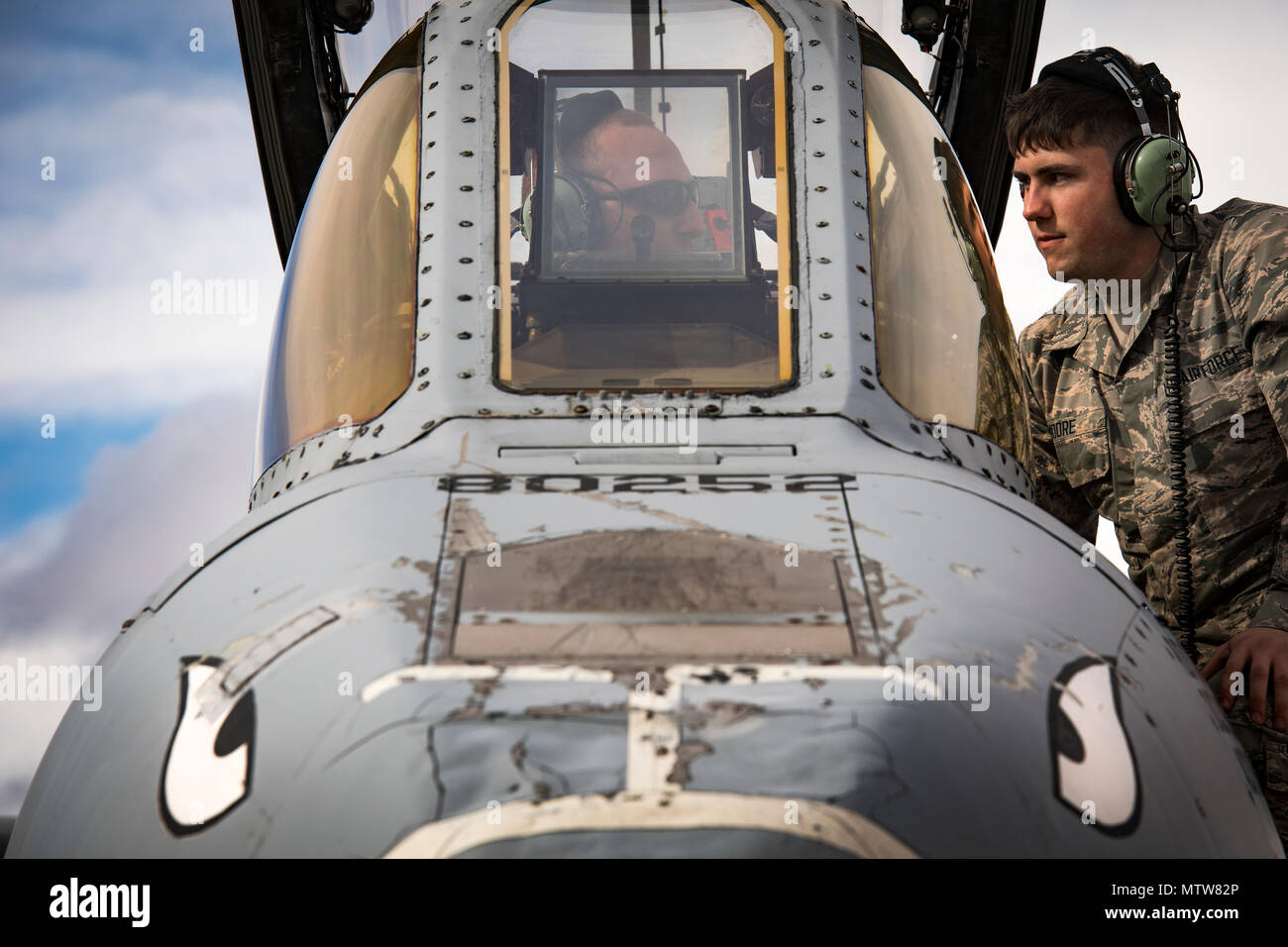 Airman 1st Class Devin Moore, right, 74th Aircraft Maintenance Unit avionics technician, speaks with a fellow maintainer while conducting maintenance on an A-10C Thunderbolt II during Green Flag-West 17-03, Jan. 23, 2017, at Nellis Air Force Base, Nev. GFW is an air-land integration combat training exercise, which hosted 12 A-10s from Moody Air Force Base, Ga. Accompanying the aircraft were 130 maintenance personnel who worked around the clock to launch 18 sorties per day. (U.S. Air Force photo by Staff Sgt. Ryan Callaghan) Stock Photo