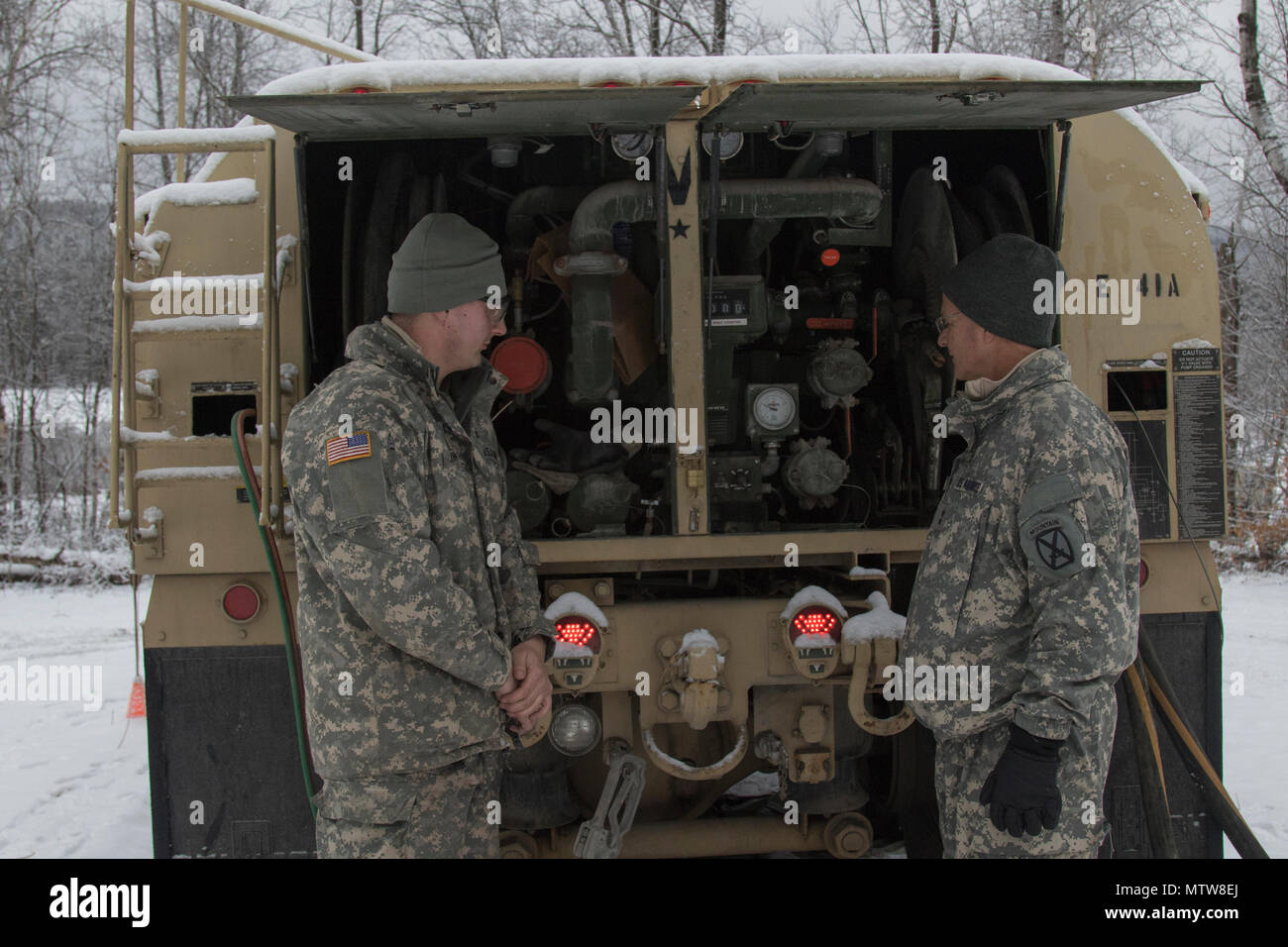 U.S. Army Sgt. Devin Johnson, left, a fueler with Golf Company, 186th  Brigade Support Battalion, Vermont National Guard, explains the different  parts of a fuel truck to Air Force Maj. Gen. Steven
