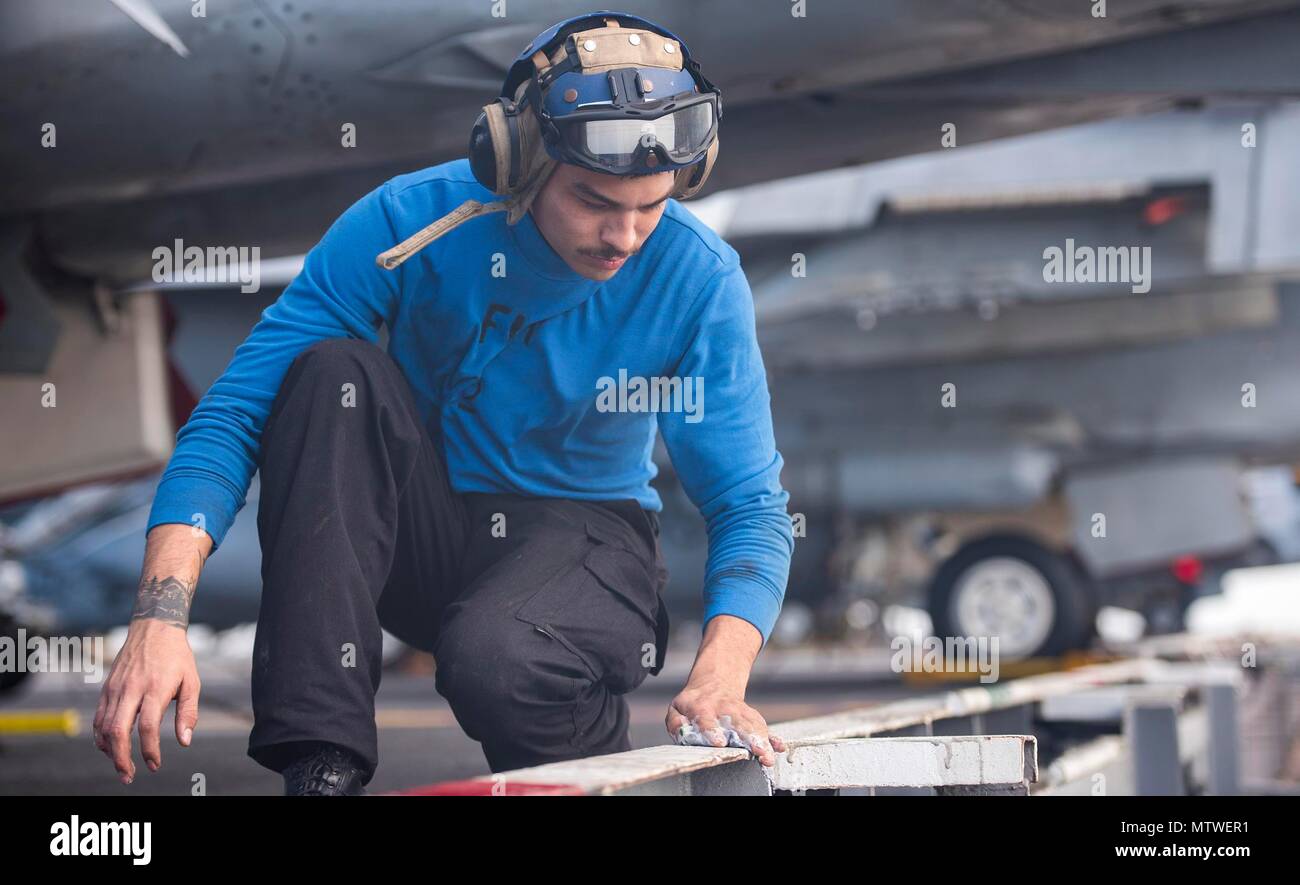 170127-N-YL257-035 ATLANTIC OCEAN (Jan. 27, 2017) Aviation Boatswain�s Mate (Handling) Airman Alex Gonzales scrubs the edge of the flight deck aboard USS George H.W. Bush (CVN 77).  The aircraft carrier is deployed with the George H.W. Bush Carrier Strike Group in support of maritime security operations and theater security cooperation efforts in the U.S. 5th and 6th Fleet areas of operation. (U.S. Navy photo by Mass Communication Specialist 3rd Class Christopher Gaines/Released) Stock Photo