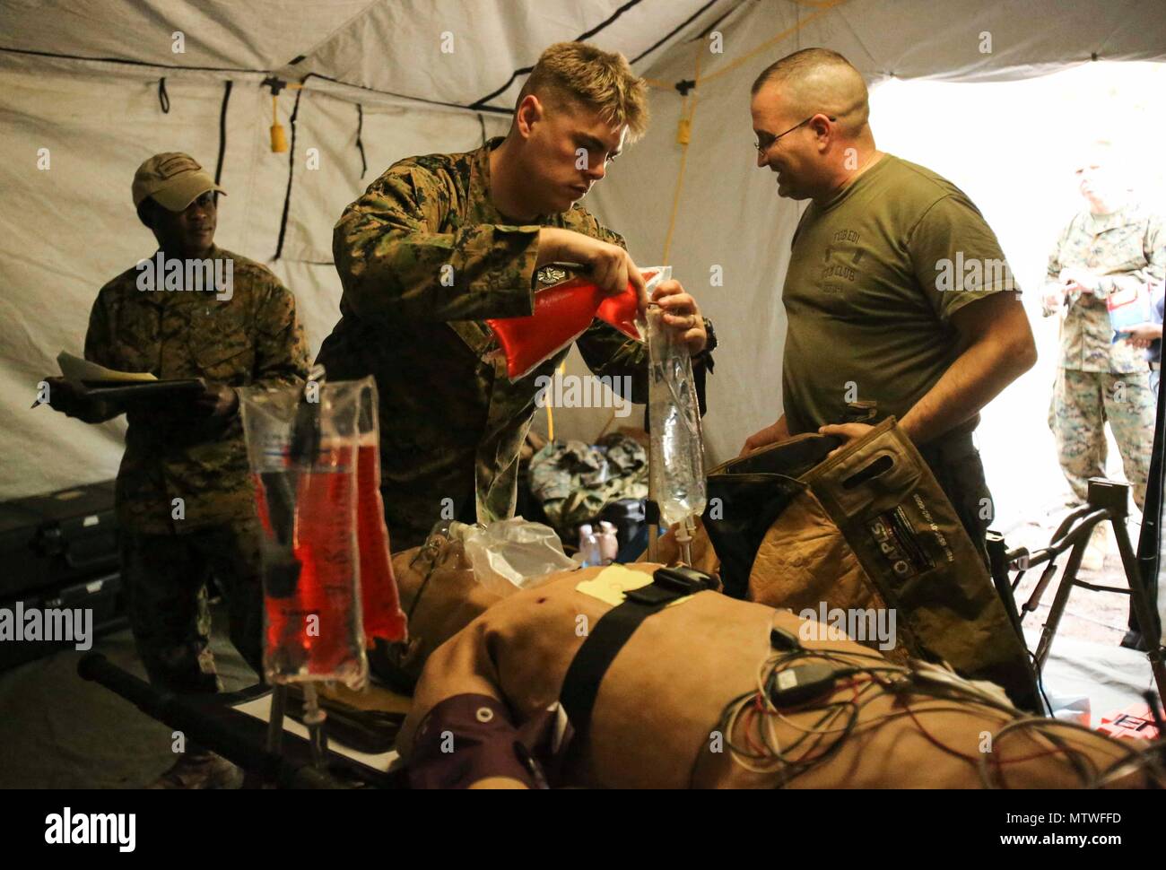 A Navy corpsman performs a blood transfusion to a notional patient as part of Naval Medical Augmentation Program training at Camp Lejeune, N.C., Jan. 26, 2017. The training is used to strengthen communication skills in an austere environment and increase combat readiness. The Sailors are with 2nd Medical Battalion. (U.S. Marine Corps photo by Cpl. Ashley Lawson) Stock Photo
