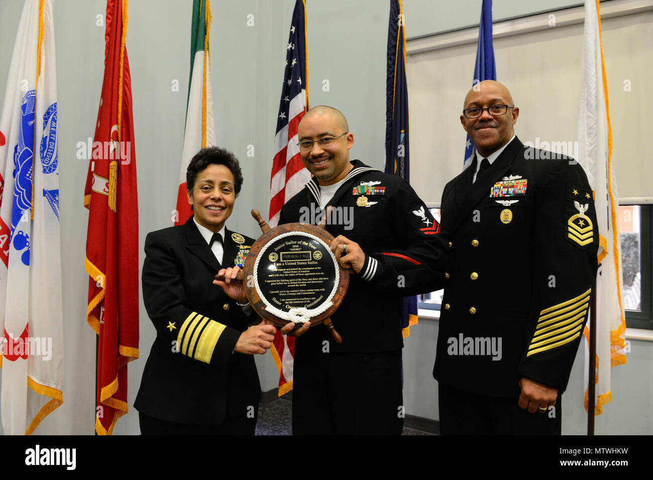 170127-N-SS492-629 NAVAL SUPPORT ACTIVITY NAPLES, Italy (Jan. 27, 2017) From left to right: Commander, U.S. Naval Forces Europe-Africa, Adm. Michelle Howard; U.S. Naval Forces Europe-Africa Junior Sailor of the Year Yeoman 2nd Class Eric Horne and U.S. Naval Forces Europe-Africa Fleet Master Chief Raymond D. Kemp Sr. pose for a photo as Howard presents Horne with a plaque at the Commander, U.S. Naval Forces Europe-Africa Sailor of the Year ceremony Jan. 27, 2017.  U.S. Naval Forces Europe-Africa, headquartered in Naples, Italy, oversees joint and naval operations, often in concert with allied, Stock Photo