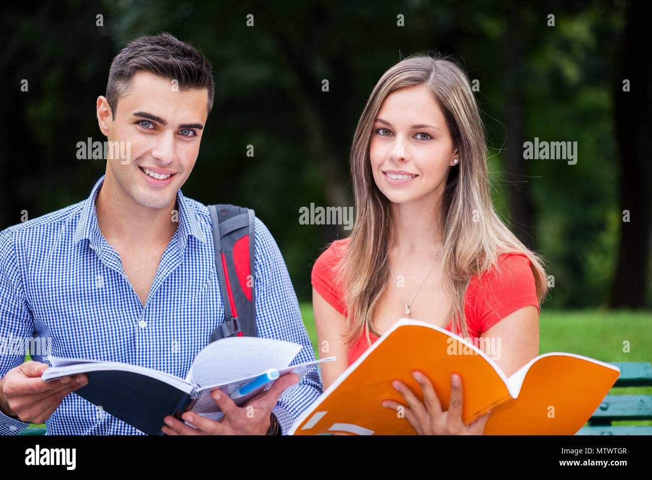 Outdoor portrait of smiling students studying in a park Stock Photo - Alamy