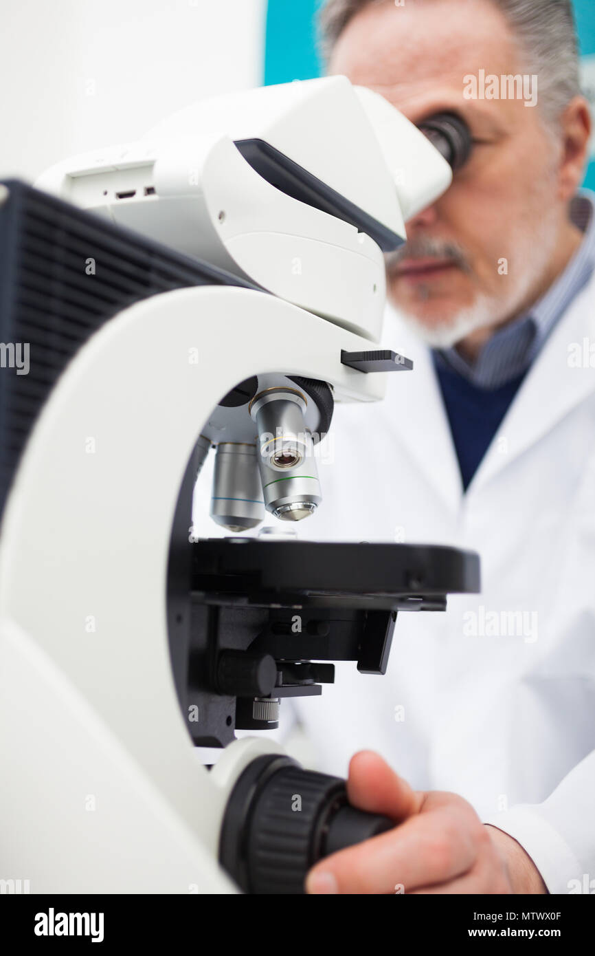 Senior scientist using a microscope in his laboratory Stock Photo - Alamy