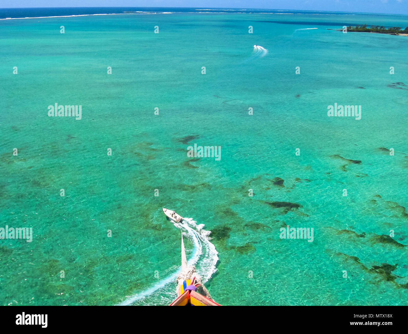 Aerial view of speedboat during a flight with parasailing, a major attraction in Deer Island, east coast of Mauritius, Indian Ocean. Stock Photo