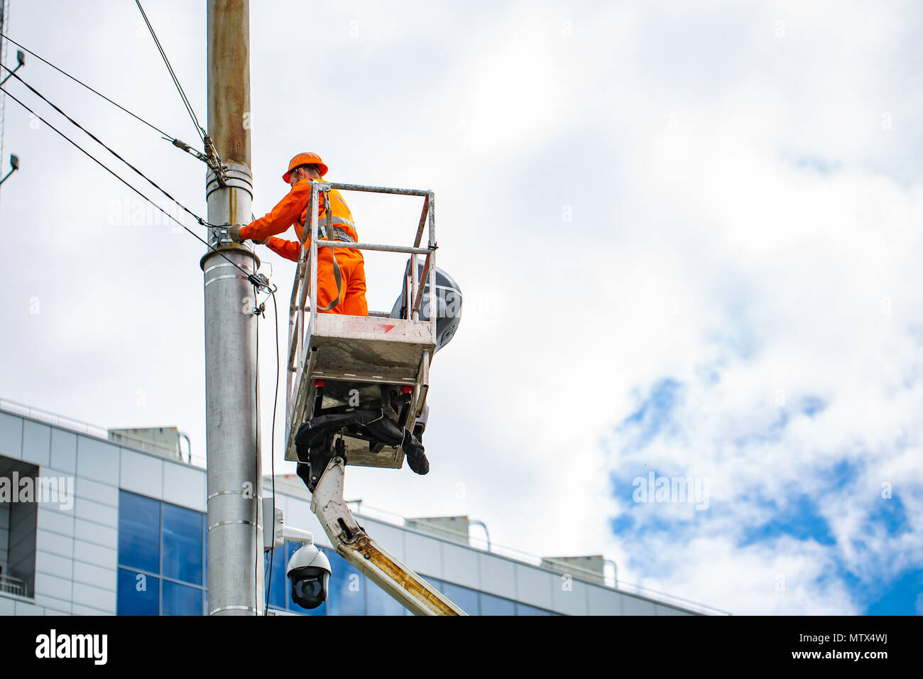 Electrician climbing work in the height on concrete electric power pole