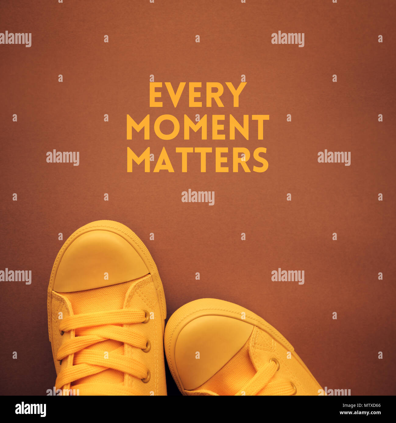 Every moment matters motivational quote, young person in casual canvas shoes standing over the text Stock Photo