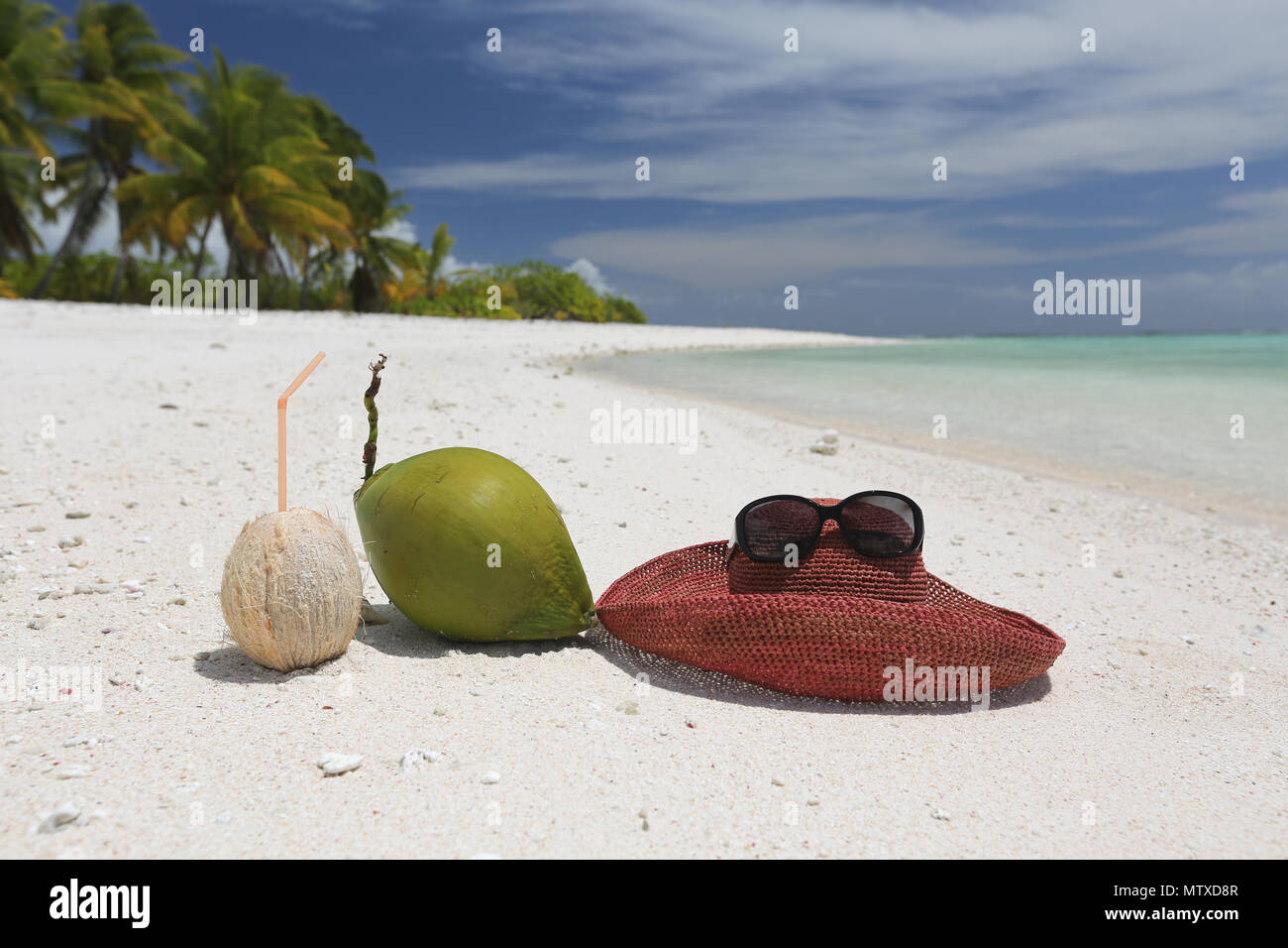 Summer hat and coconuts on tropical sandy beach, Christmas Island, Kiribati Stock Photo