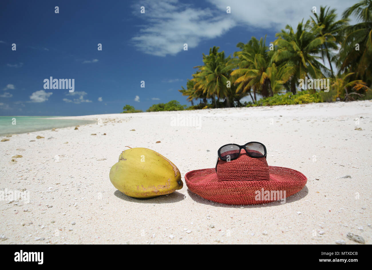 Summer hat and coconut on tropical sandy beach, Christmas Island, Kiribati Stock Photo