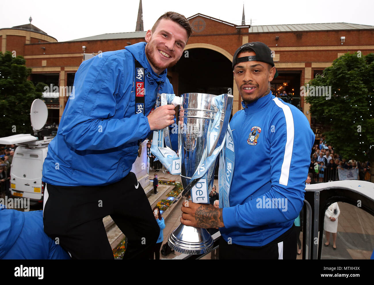 Coventry City's Chris Stokes (left) and Jonson Clarke-Harris with the trophy during the Sky Bet League Two promotion parade in Coventry. PRESS ASSOCIATION Photo. Picture date Wednesday May 30, 2018. See PA story SOCCER Coventry. Photo credit should read: Nigel French/PA Wire Stock Photo