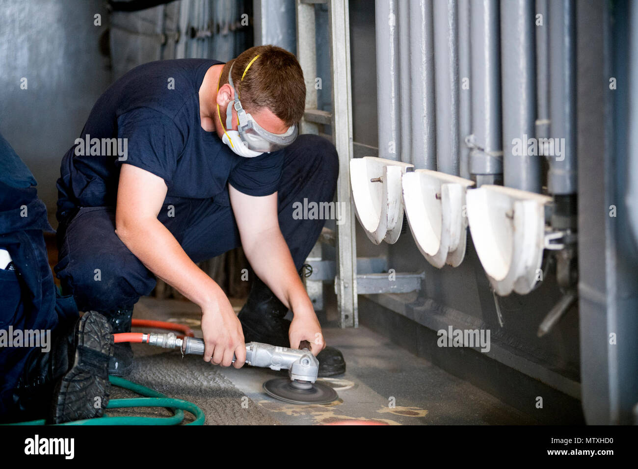 Seaman Cameron Yellin, U.S. Navy, removes rust and performs sanding on ...