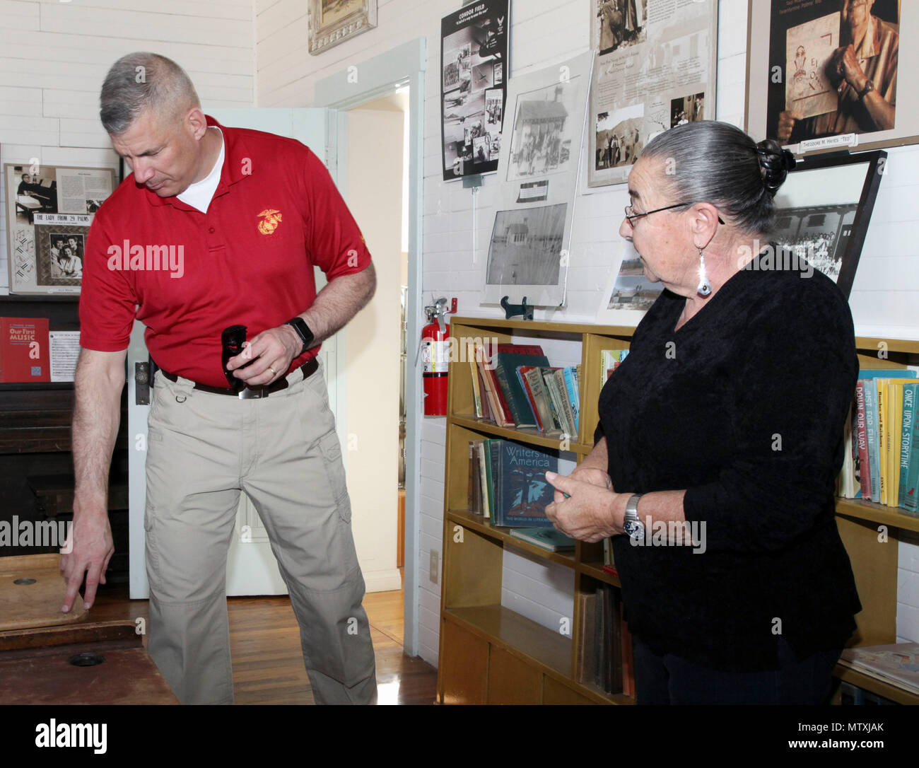 Brig. Gen. William F. Mullen III, Combat Center Commanding General, inspects a desk with Twentynine Palms Historical Society volunteer Pat Rimmington during a tour of the Old Schoolhouse Museum in Twentynine Palms, Calif., Jan. 31, 2017. Mullen and his wife, Vicki, toured the facility with Sgt. Maj. Michael J. Hendges, Combat Center Major; Cpl. Ben Mills, driver; Jim Ricker, Assistant Chief of Staff for Government and External Affairs; and Kristina Becker, Combat Center External Affairs Director. (Official Marine Corps photo by Kelly O'Sullivan/Released) Stock Photo