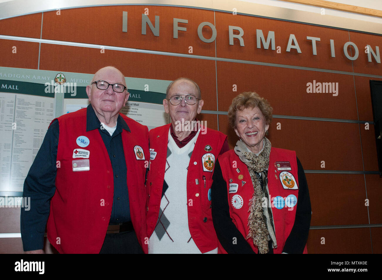 (From left to right) Gary Leakes, Aldro Grieco, and Pat Trobaugh, volunteers with the American Red Cross Madigan Army Medical Center Volunteer Program, pause for a photo near the front information desk of the MAMC Joint Base Lewis-McChord, Washington, Jan. 18. The Red Cross volunteer program at MAMC aims to provide quality of care, directions and personal care to service members, their dependents and veterans. (U.S. Army photo by Sgt. David N. Beckstrom, 5th Mobile Public Affairs Detachment, I Corps) Stock Photo
