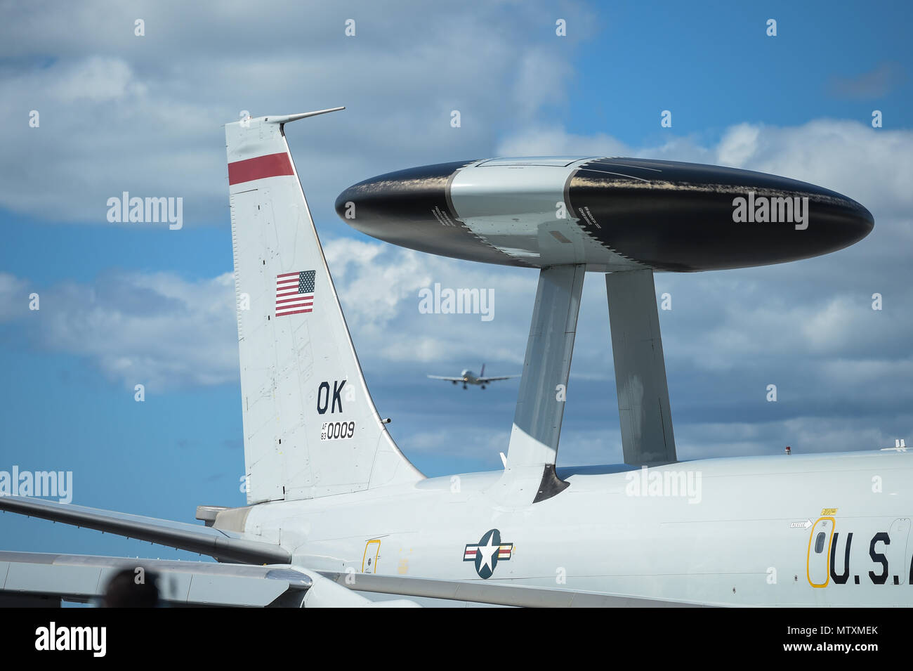 An E 3 Sentry Airborne Warning And Control System Aircraft Taxis Into Place Jan 25 After Returning From A Mission At Joint Base Pearl Harbor Hickam Hawaii While A Passenger Airplane Prepares To Land
