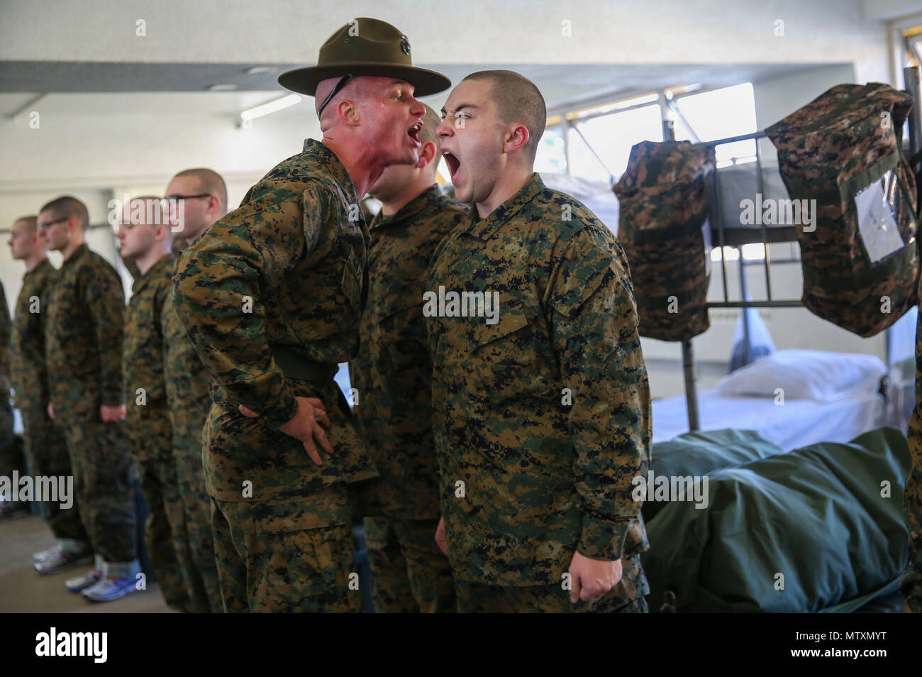 A drill instructor with Kilo Company, 3rd Recruit Training Battalion, instructs a recruit to respond louder during pick up at Marine Corps Recruit Depot San Diego, Jan. 27. The recruits will spend pick up with their drill instructors learning the rules and regulations of recruit training, regarding everything from how to act in the squad bay to how to speak to drill instructors. Annually, more than 17,000 males recruited from the Western Recruiting Region are trained at MCRD San Diego. Kilo Company is scheduled to graduate April 21. Stock Photo
