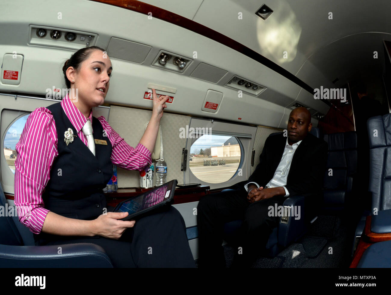 170130-F-WU507-008: Staff Sgt. Autumn Murphy, 99th Airlift Squadron flight attendant, points out the emergency exits during a C-20B pre-flight safety brief at Joint Base Andrews, Maryland, Jan. 27, 2017. FAs are often praised for their culinary artistry and the uniqueness of preparing full meals while crossing the nation or oceans; however, foremost they are safety experts, and even though she is briefing two mission-essential personnel, Murphy ensures the MEPs receive a full brief prior to taking off for a mission to Panama City, Panama. (U.S. Air Force photo by Senior Master Sgt. Kevin Walla Stock Photo