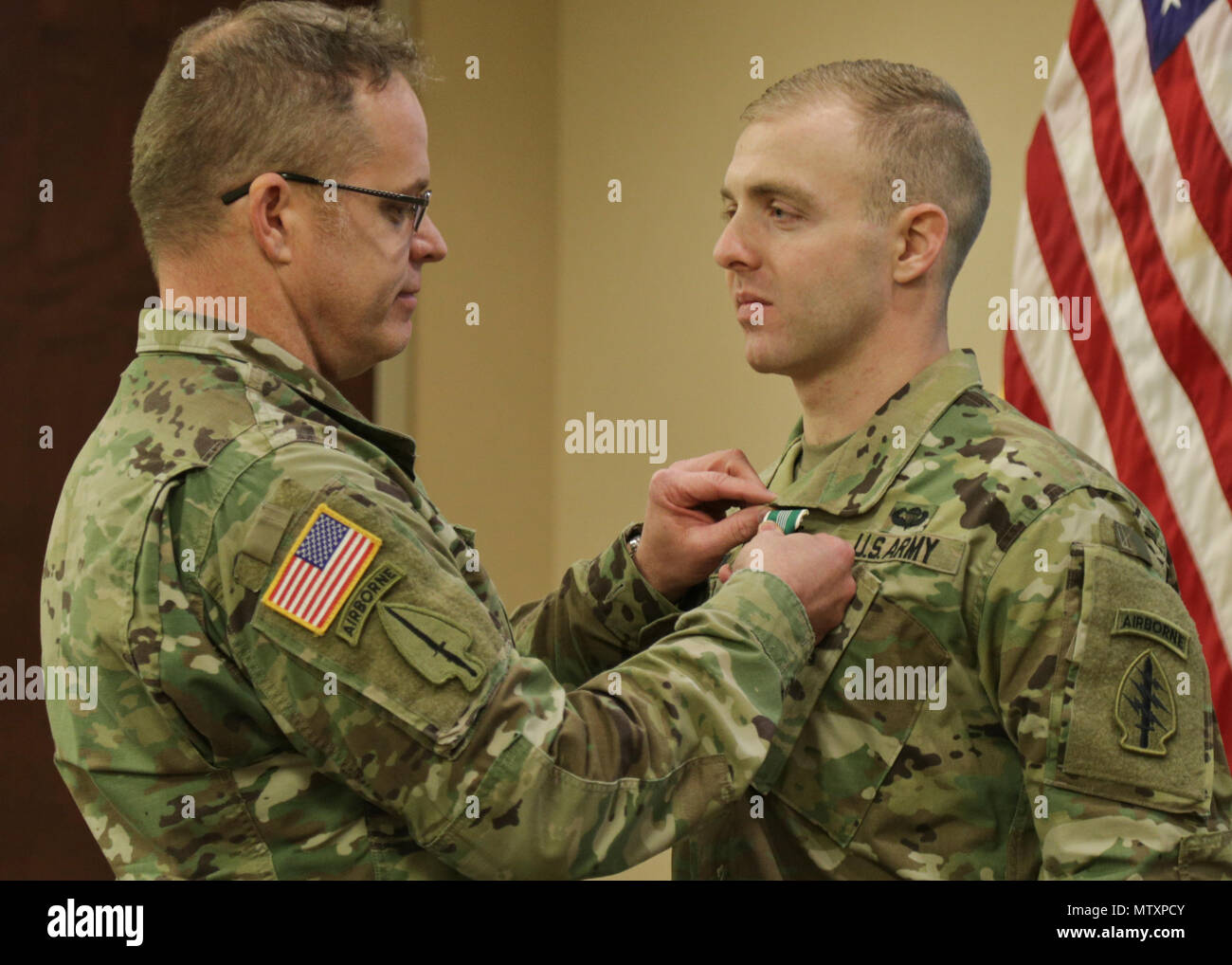 Sgt. Maj. William Barr (Left) with United States Army Special Operations  Command, awards Spc. Seth Ravid (Right) with 4th Battalion, 7th Special  Forces Group (Airborne) an Army Commendation Medal during an AG Corps brief  at the 7th SFG(A)'s Auditorium Jan. 27, 2017 on Eglin Air Force Base,  Florida. Spc. Ravid won the USASOC level AG Corps Soldier of the Year  competition at Fort Bragg and is slated to compete at the Army-level  competition at Fort Jackson in June. (U.S. Army photos by Staff Sgt. Brian  K. Ragin Jr.) Stock Photo