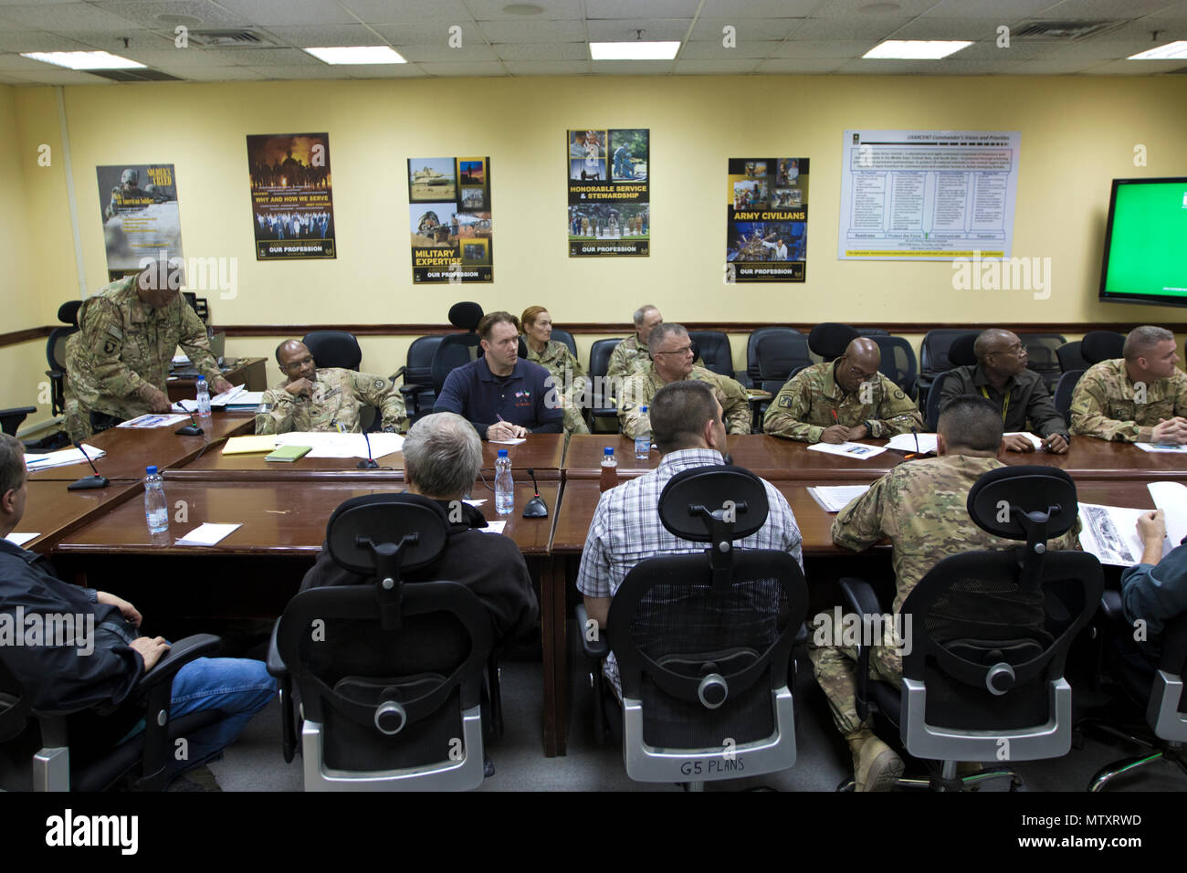 Rick Gravely, the 1st Sustainment Command (Theater) deputy safety director, (left), talks about the 2017 Worldwide Ammunition Logistics and Explosives Safety Review timeline in Camp Arifjan, Kuwait, on Jan. 20, 2017. The review, conducted by the U.S. Army Defense Ammunition Center, will carry out evaluations against a recognized standard, provide solutions to resolve issues or problems, teach and enhance knowledge base and to emphasize the fact that the reviews are not punitive in nature. (U.S. Army Photo by Staff Sgt. Dalton Smith) Stock Photo