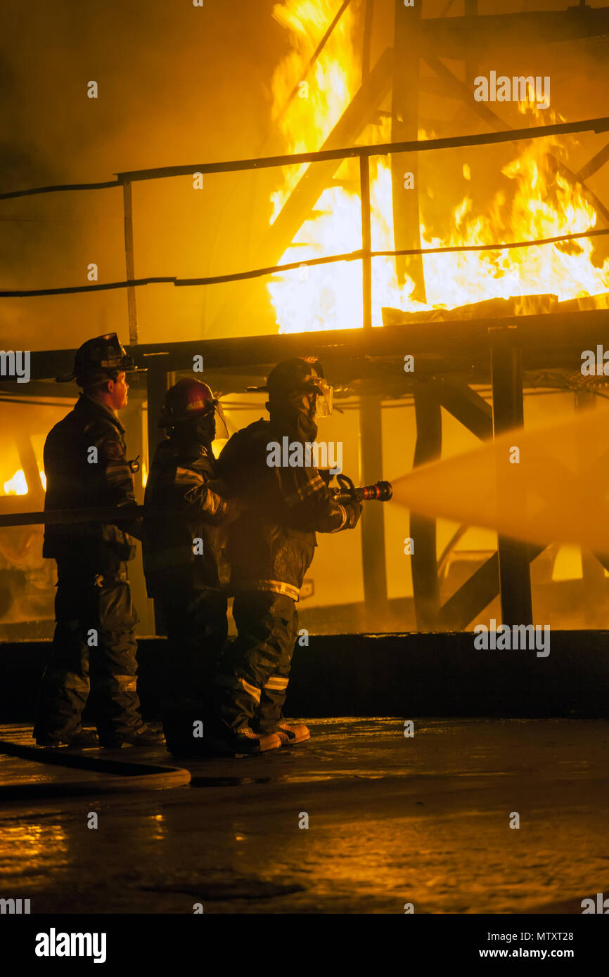 JOHANNESBURG, SOUTH AFRICA - MAY, 2018 Firefighters spraying water at burning structure during firefighting training exercise Stock Photo