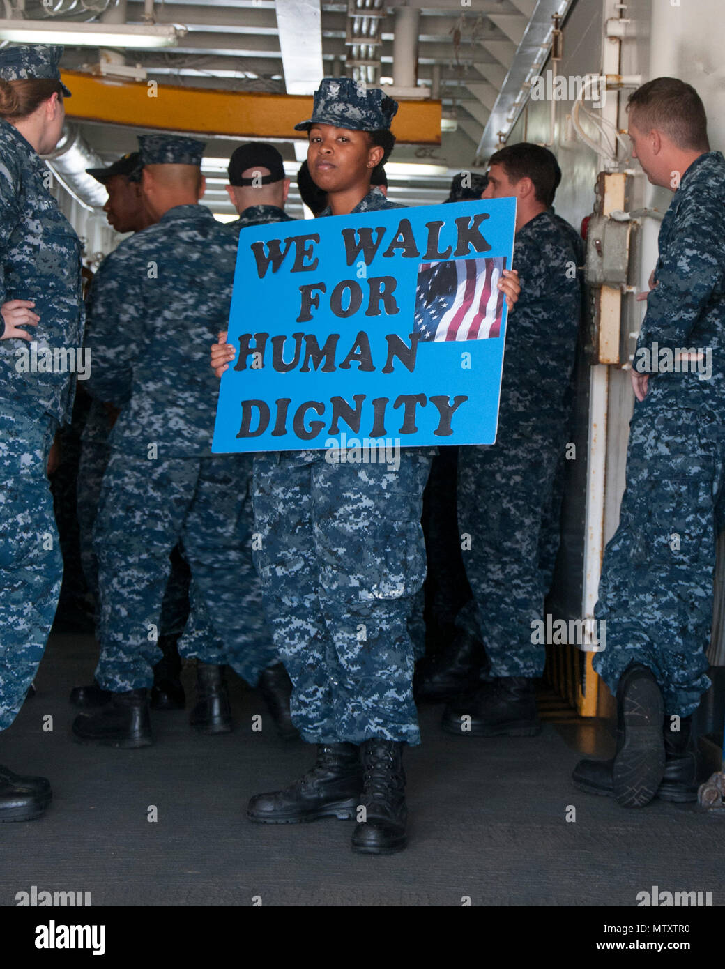 170131-N-DS883-003    SANTA RITA, Guam (Jan. 31, 2017) Hospital Corpsman 3rd Class Sophie Karanja, a Sailor assigned to the submarine tender USS Frank Cable (AS 40), holds a sign before beginning a march honoring Dr. Martin Luther King Jr. aboard the ship, January 31. The ship’s diversity committee held the event to reenact the1965 Selma-to-Montgomery March for voting rights led by Martin Luther King Jr.’s Southern Christian Leadership Conference. (U.S. Navy photo by Mass Communication Specialist Seaman Heather C. Wamsley/Released) Stock Photo