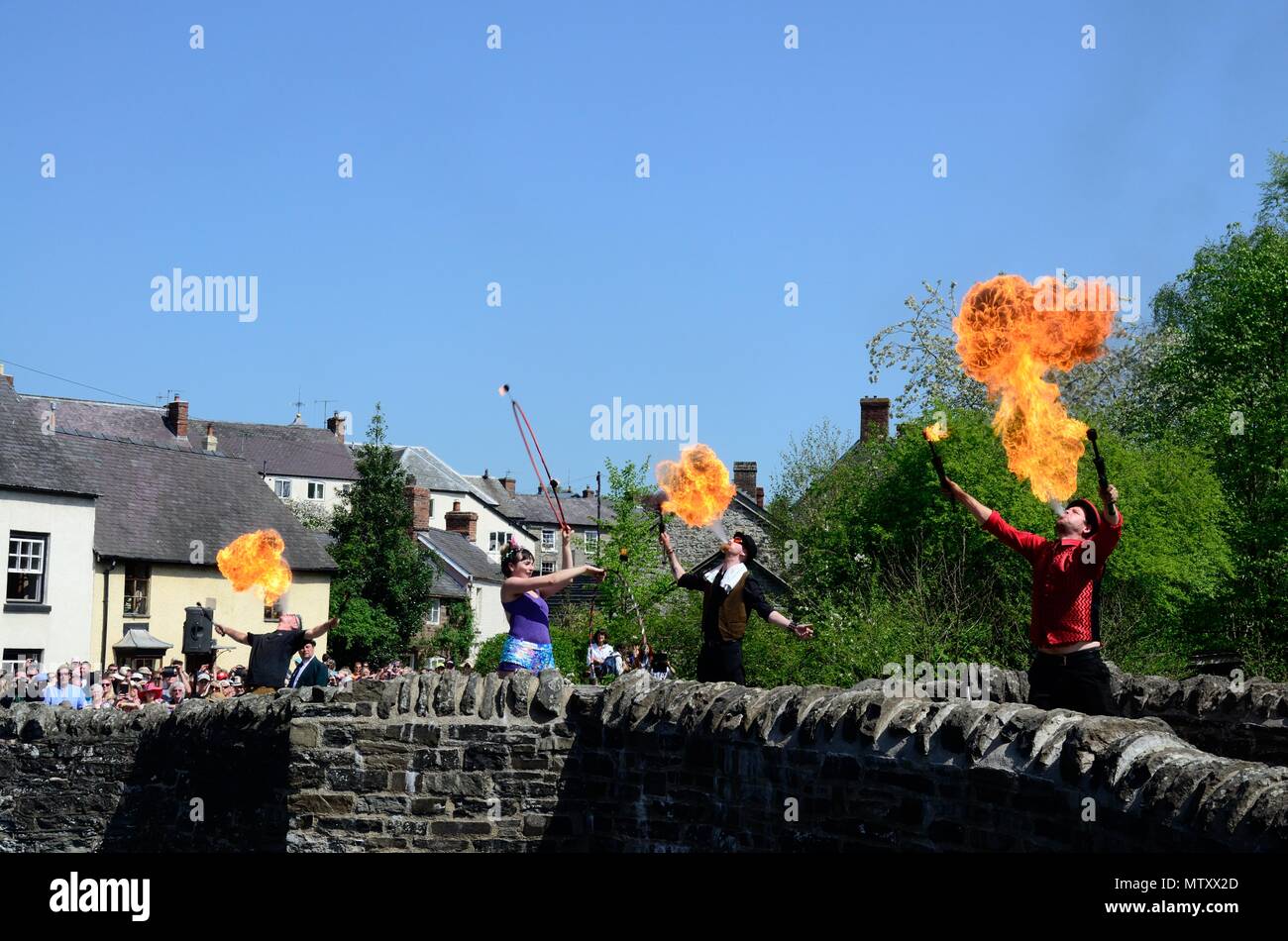 Fire eaters entertaining crouds on Clun medieval bridge at the Clun Green man Festival Shropshire England Stock Photo